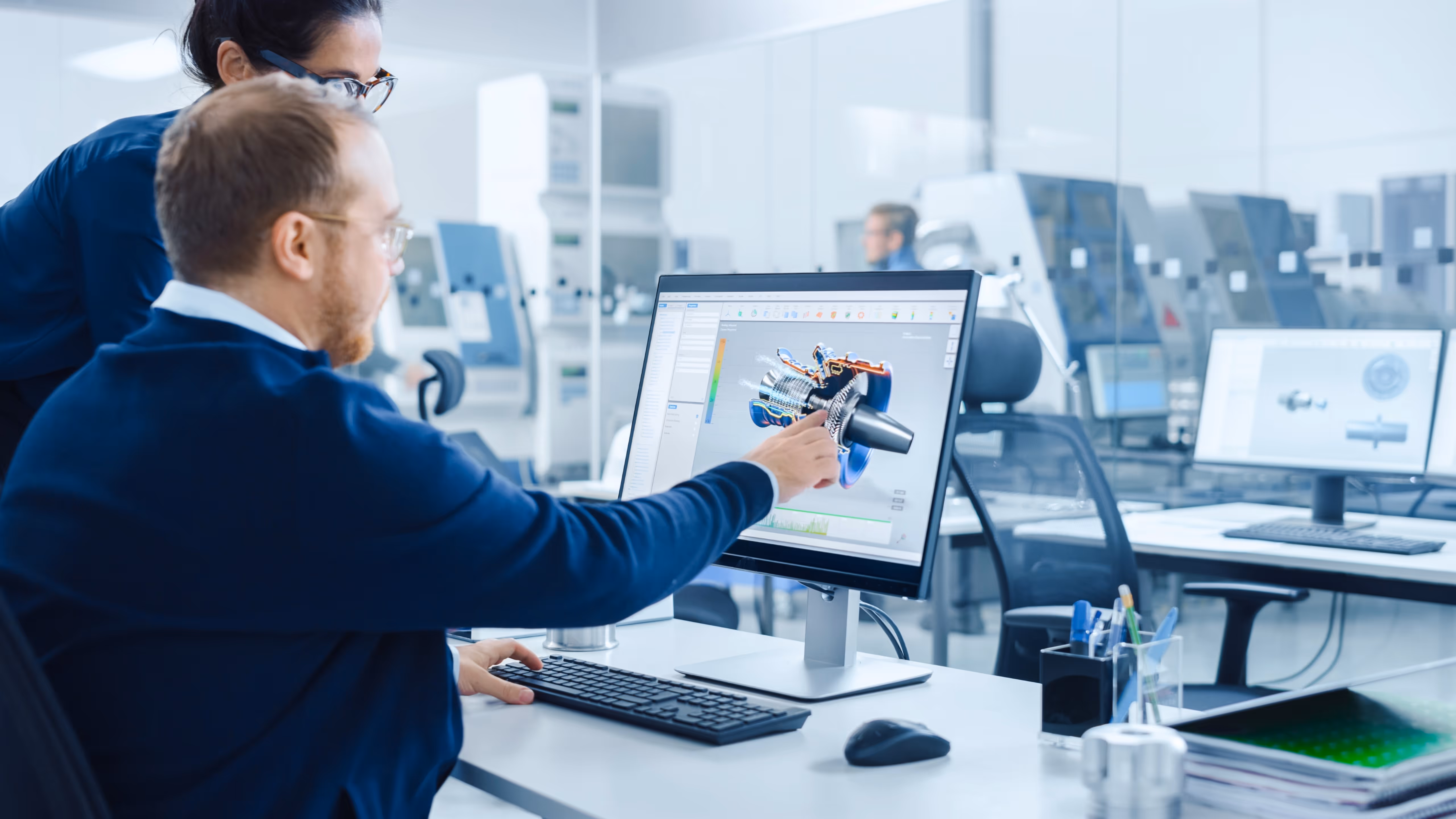 A man and a woman working on a computer. They are looking at a model for 3D printing.
