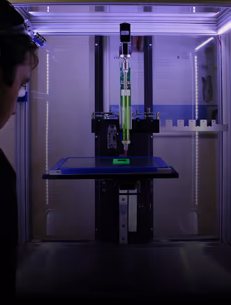 A 3D printer making a small, neon green square