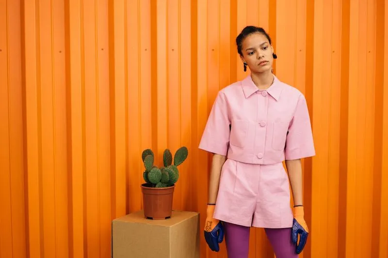 Woman standing next to a plant.
