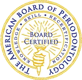 Seal of The American Board of Periodontology with the text 'Board Certified', featuring a hand holding a torch surrounded by sun rays.