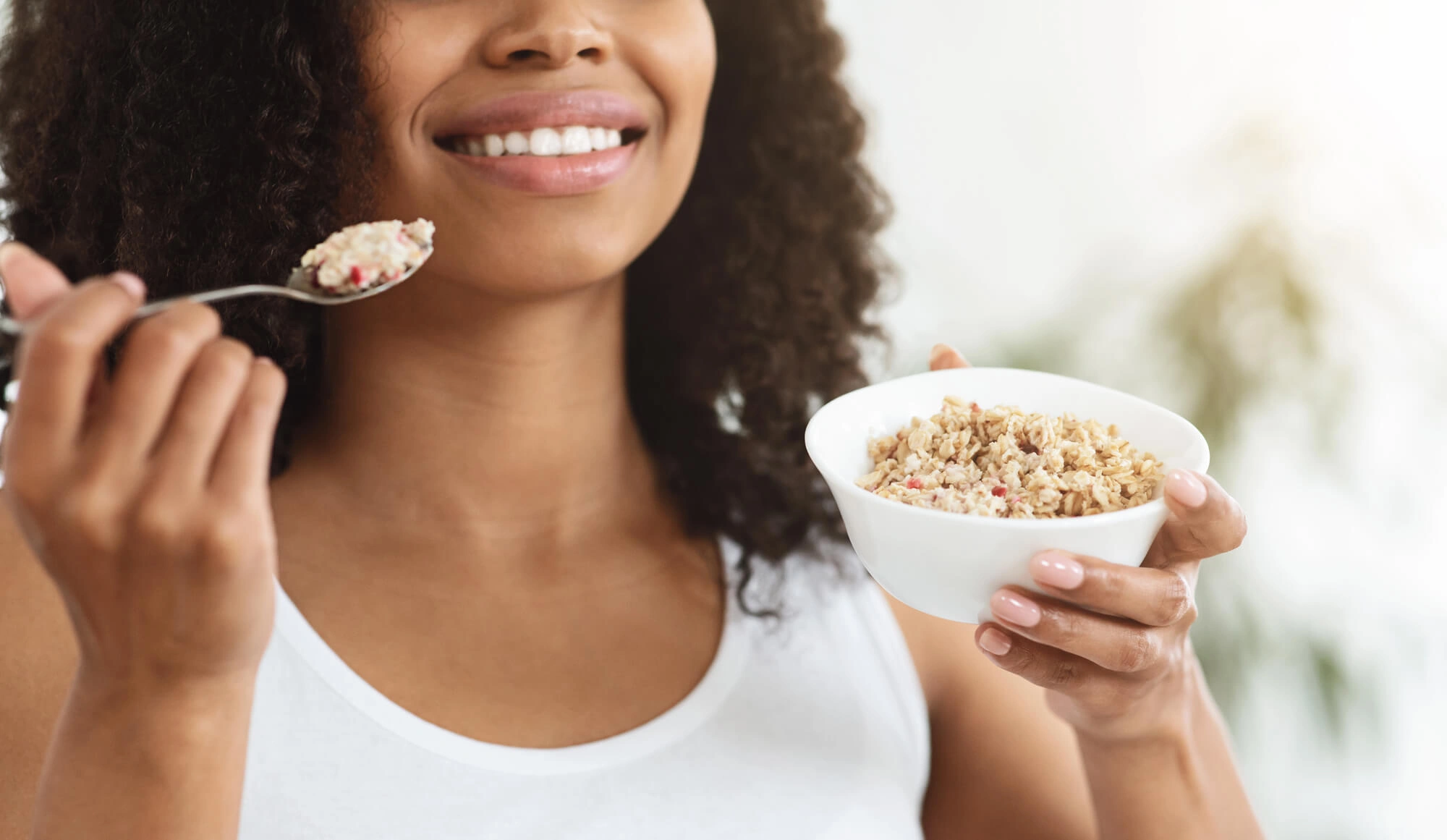 Woman eating oatmeal before and after dental implants