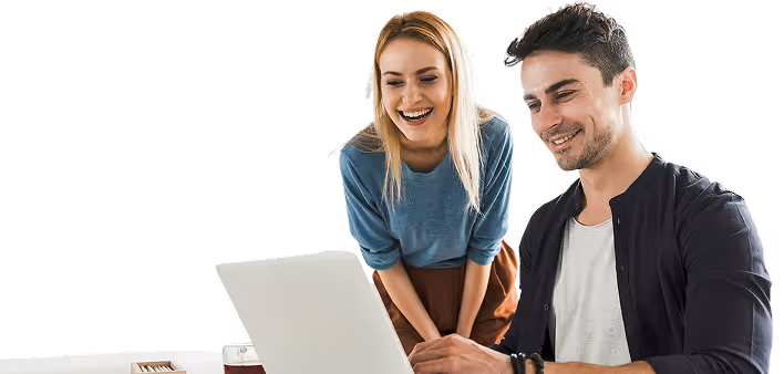 Deux personnes interagissent joyeusement tout en regardant un ordinateur portable, illustrant un moment de travail d'équipe ou d'intérêt partagé.