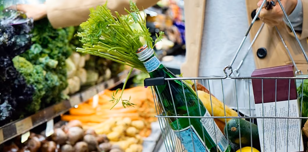 Personne tenant un panier de course dans un supermarché