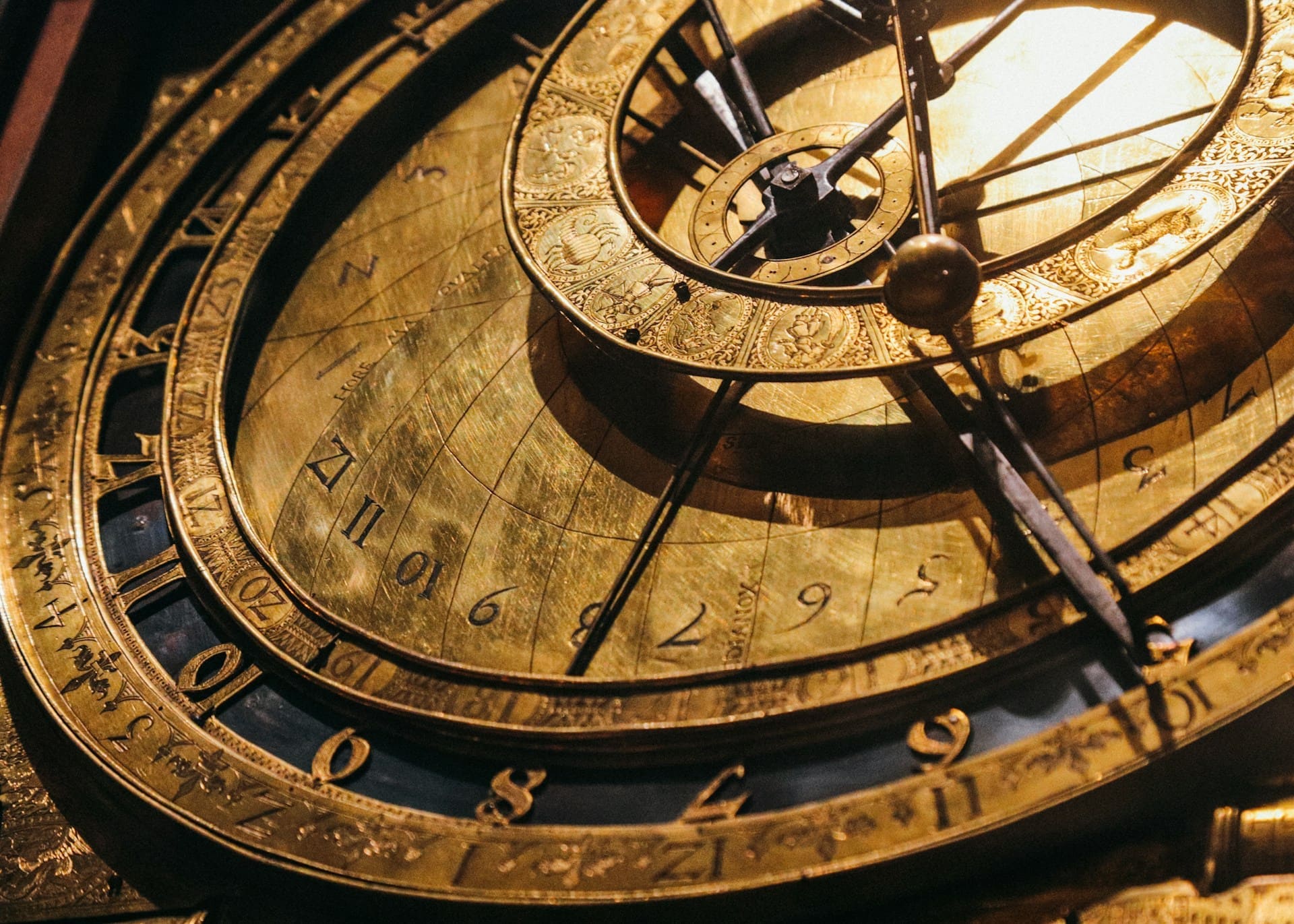 Gros plan sur un mécanisme d'horlogerie astronomique ancien en laiton, symbolisant le passage du temps et les grandes étapes de l'histoire de l'électricité en France et des découvertes scientifiques.