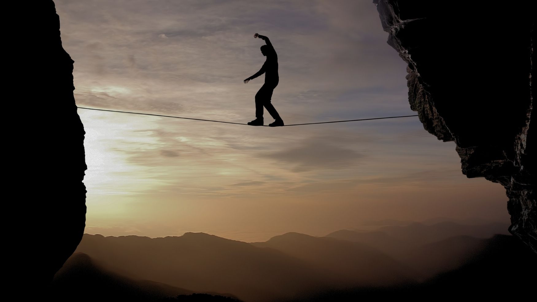 Un équilibriste traverse un espace entre deux falaises