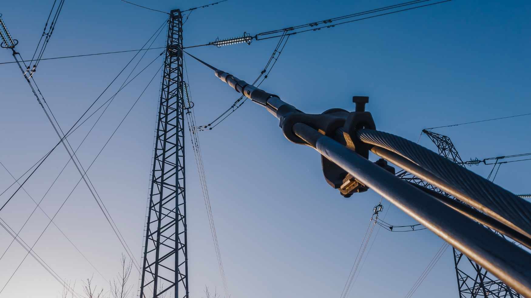 Vue d'en bas poteaux et lignes électriques