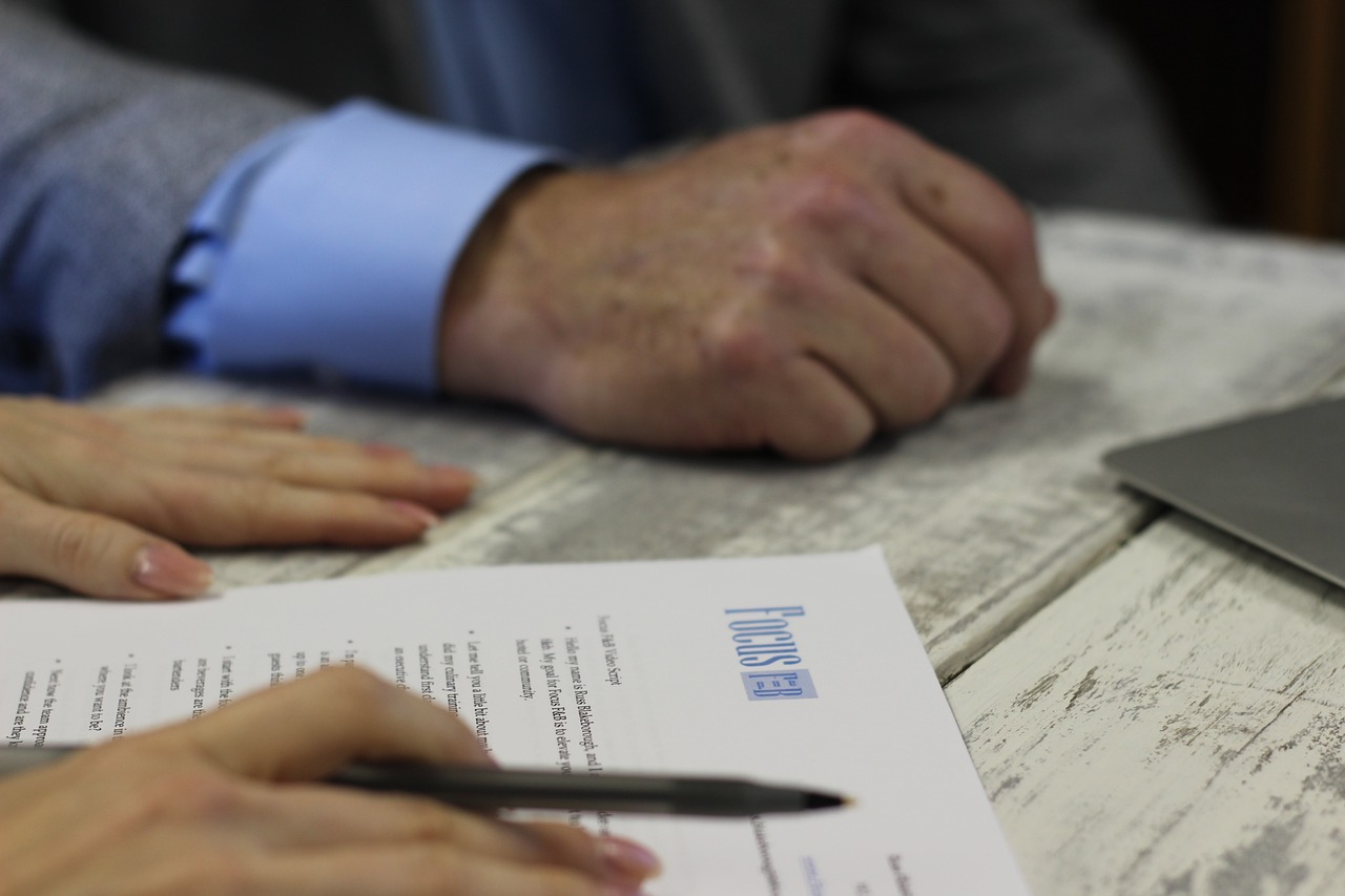 Focused view on a contract being signed, with a logo that reads 'Trust Me', implying a formal agreement, potentially related to contractor termination matters.