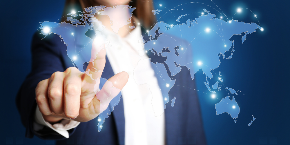 A person in a suit is touching a floating digital world map with highlighted global connections, symbolizing international business or networking.