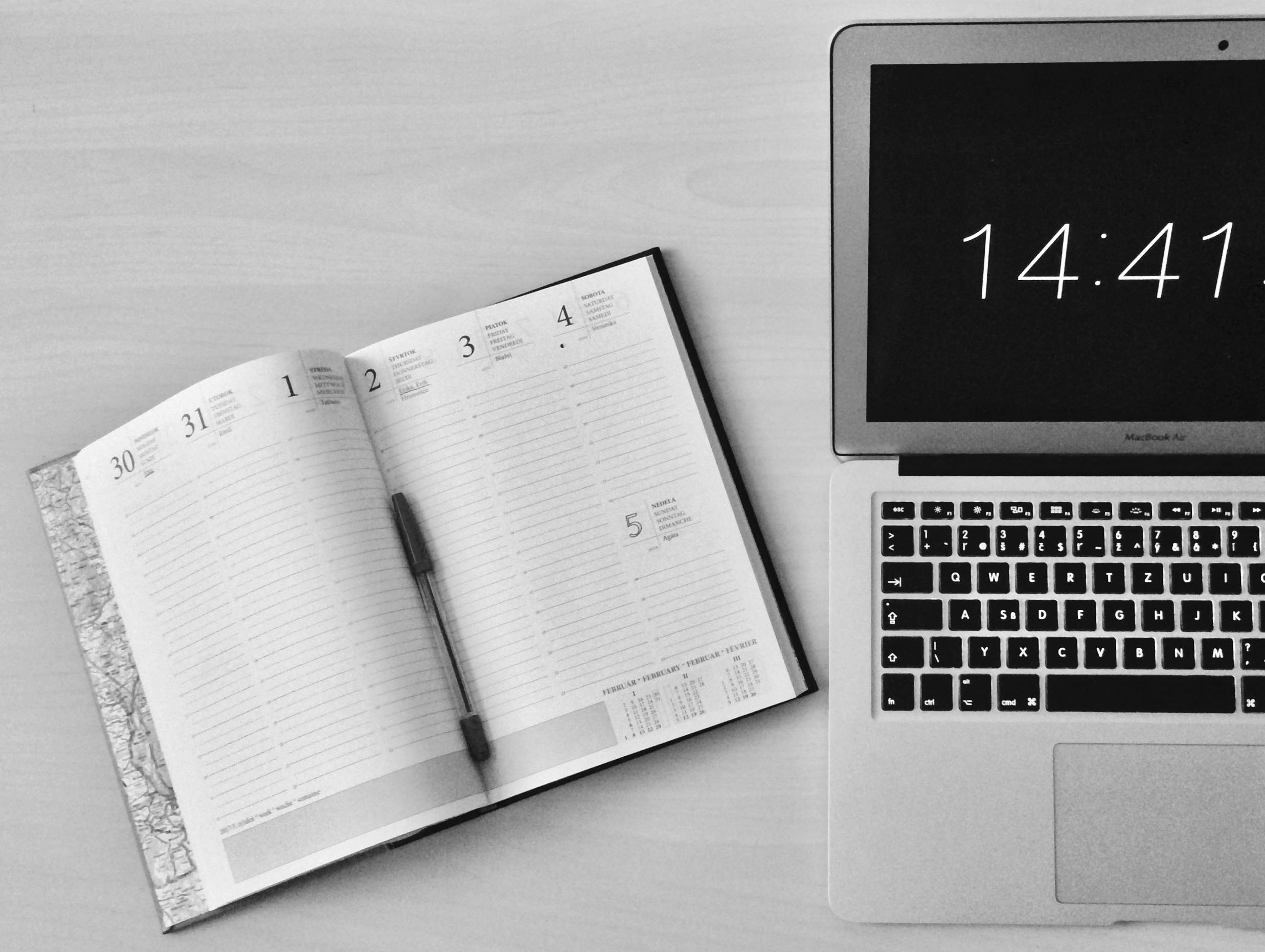 Planner and laptop on a desk.