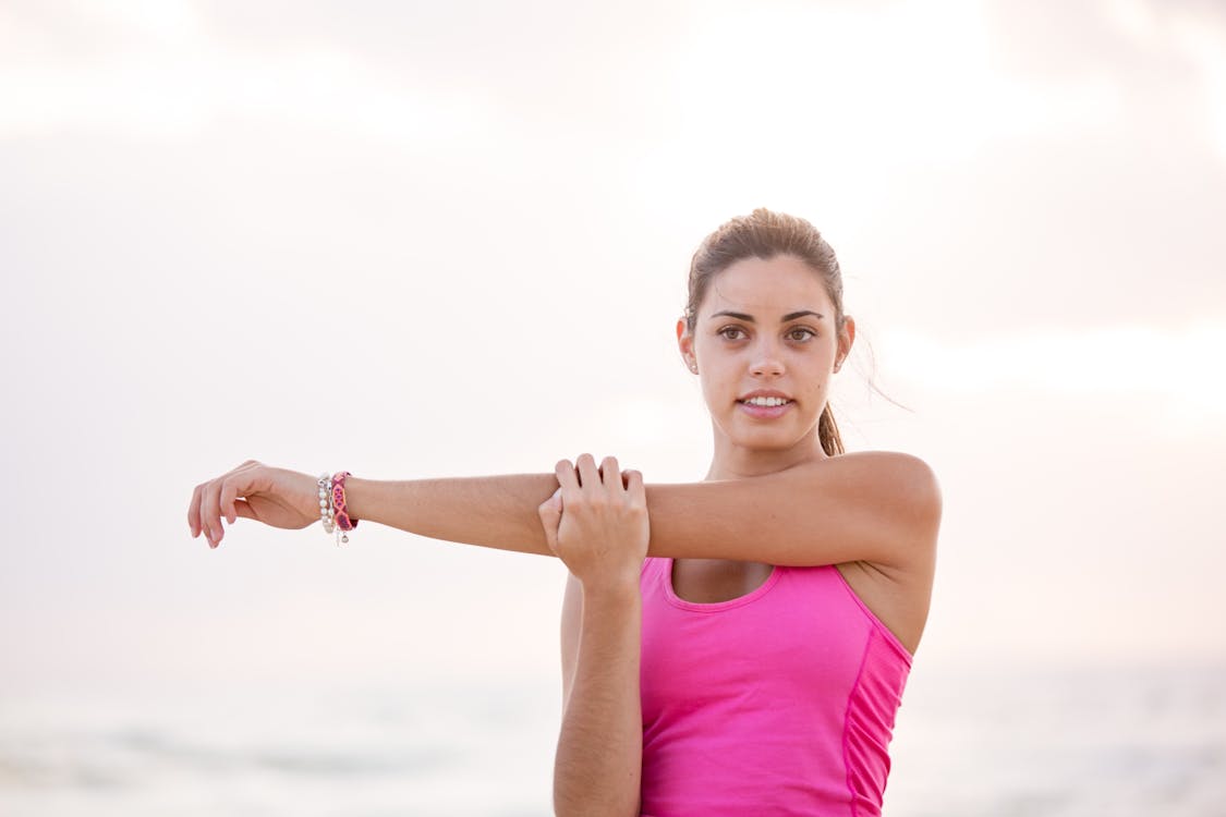 Gratis Fotografía De Mujer En cam-velascoiseta Rosa Sin Mangas Estirando El Brazo Foto de stock