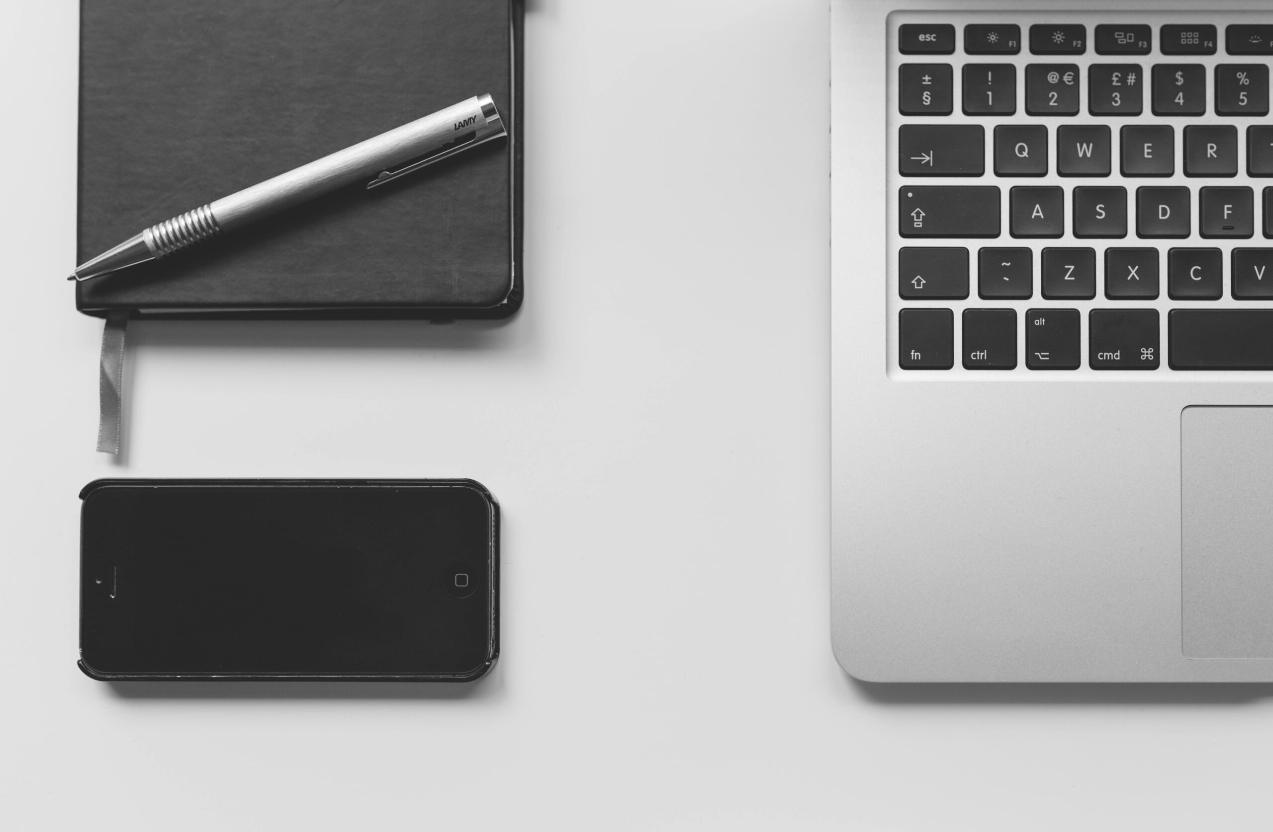 A minimalist workspace of a part-time copywriter with a laptop, pen, and notebook.