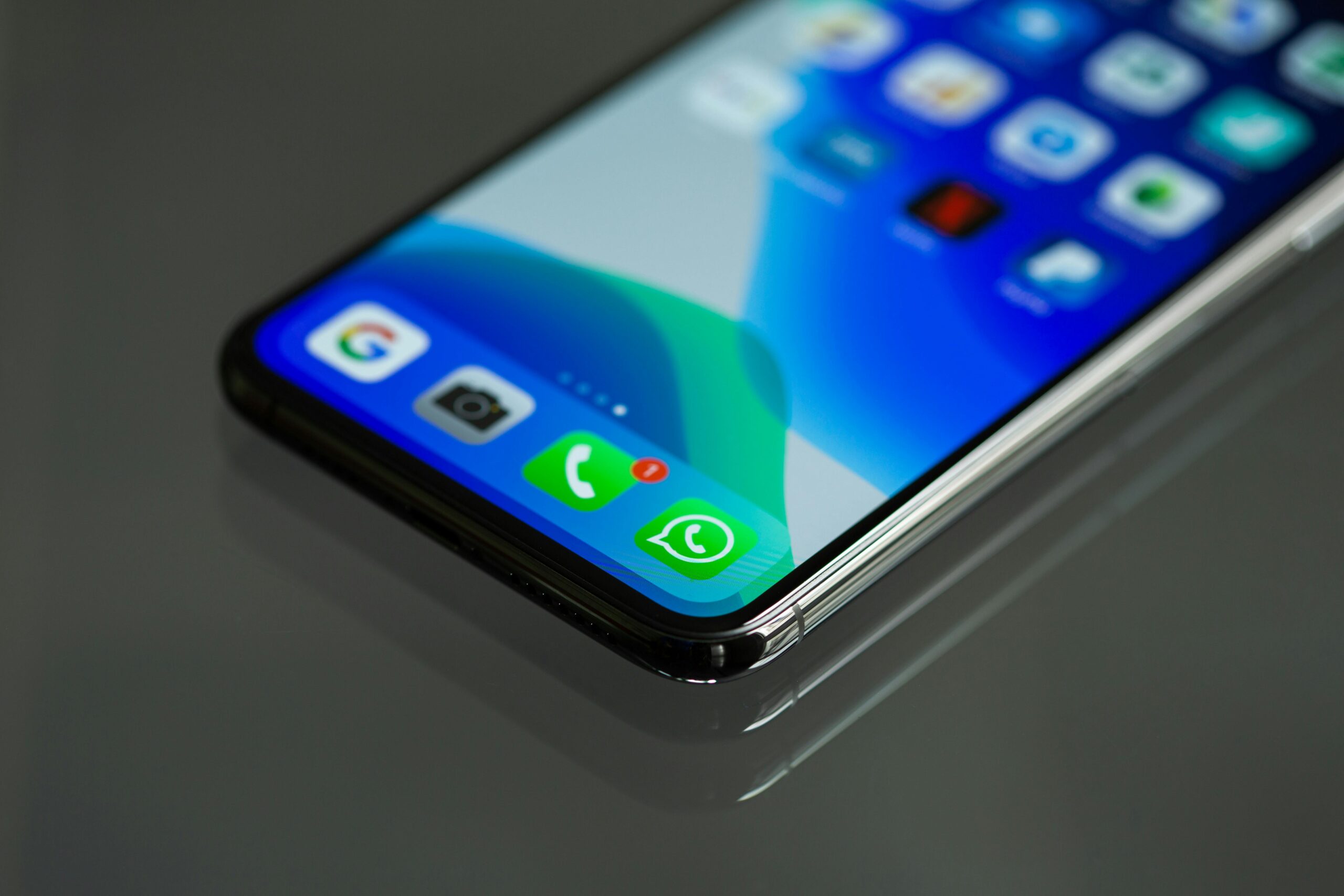 Close-up of a smartphone screen displaying various app icons, focusing on the phone's edge.
