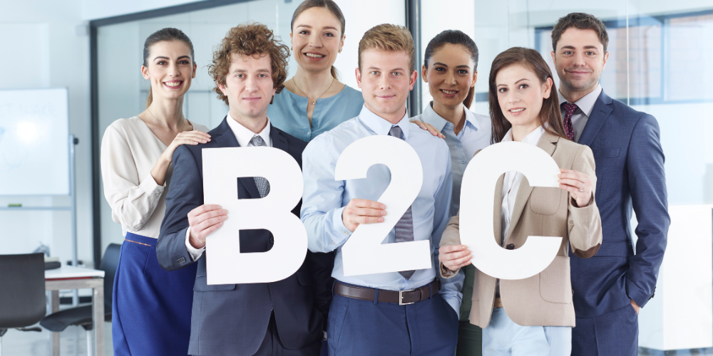 A group of professionals holding letters that spell out 'B2C', which stands for Business to Consumer, indicating a marketing or sales concept.