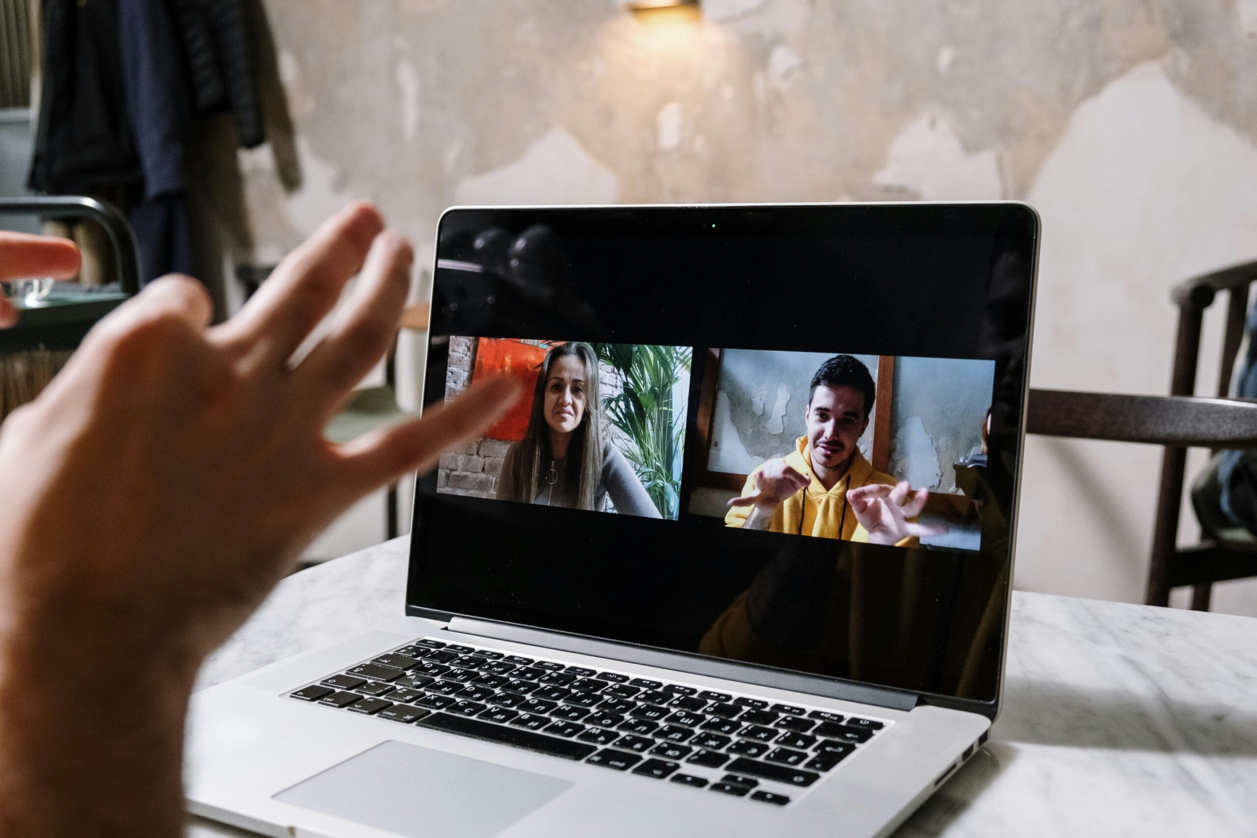 Two people engaging in a friendly video call on a laptop.