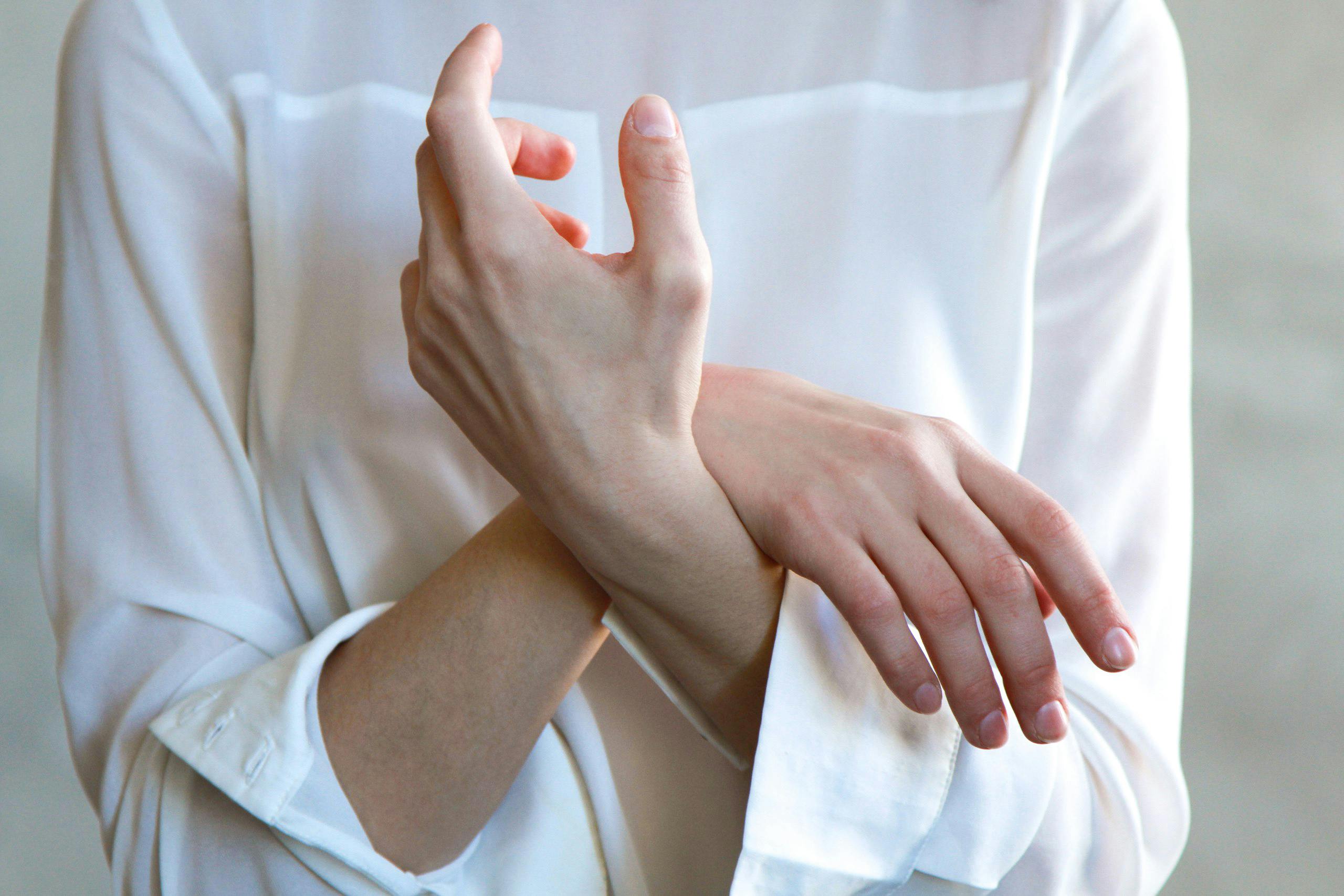 Close-up of a person's hands performing a stretching exercise to prevent RSI