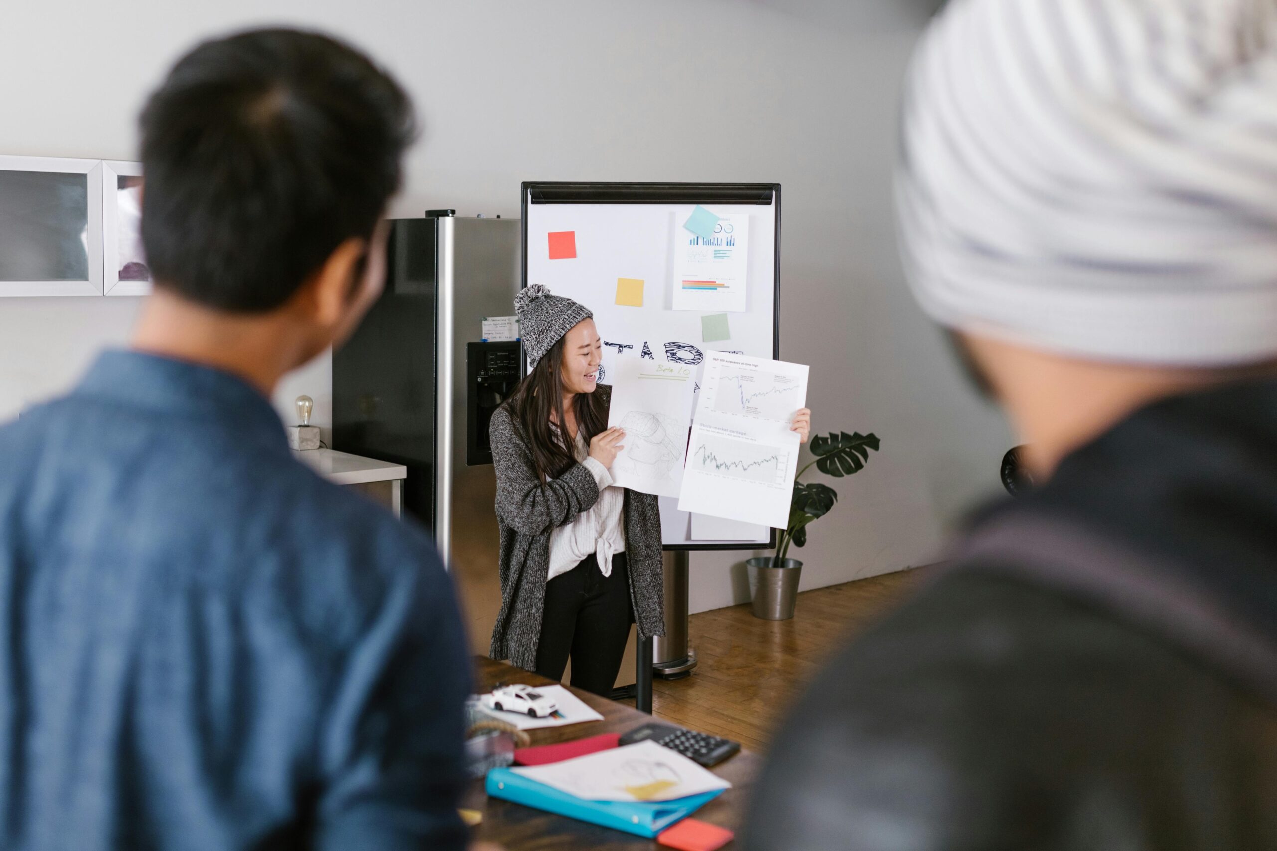 Person presenting marketing graphs to a team.