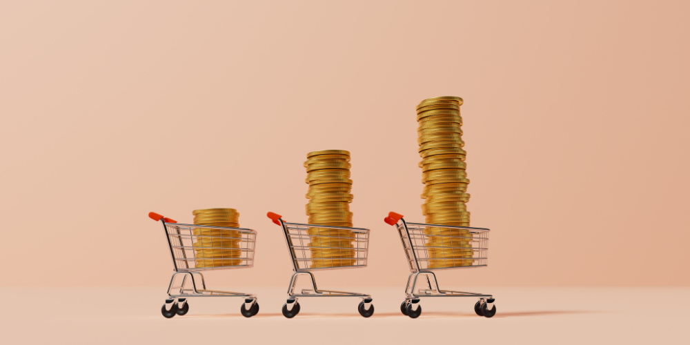 Three shopping carts with increasing stacks of gold coins, depicting growing wealth, savings, or investment concept.