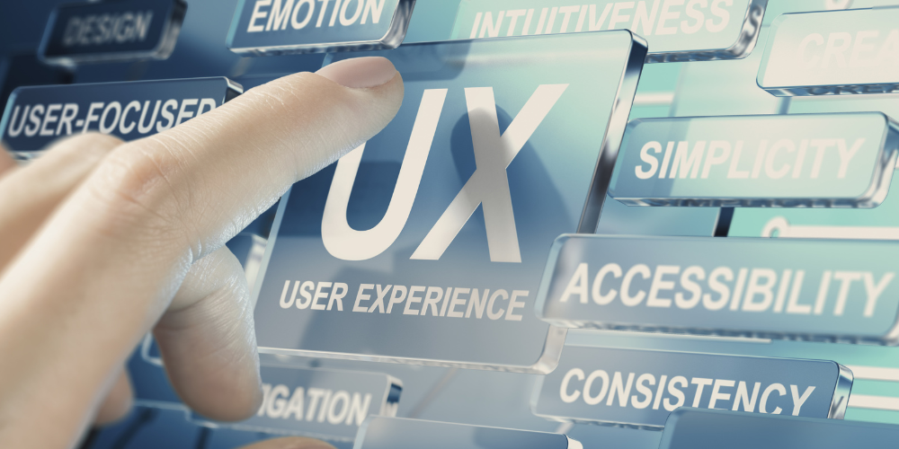 A hand interacting with a touch screen interface displaying the acronym UX and related terms like user experience, accessibility, and simplicity.