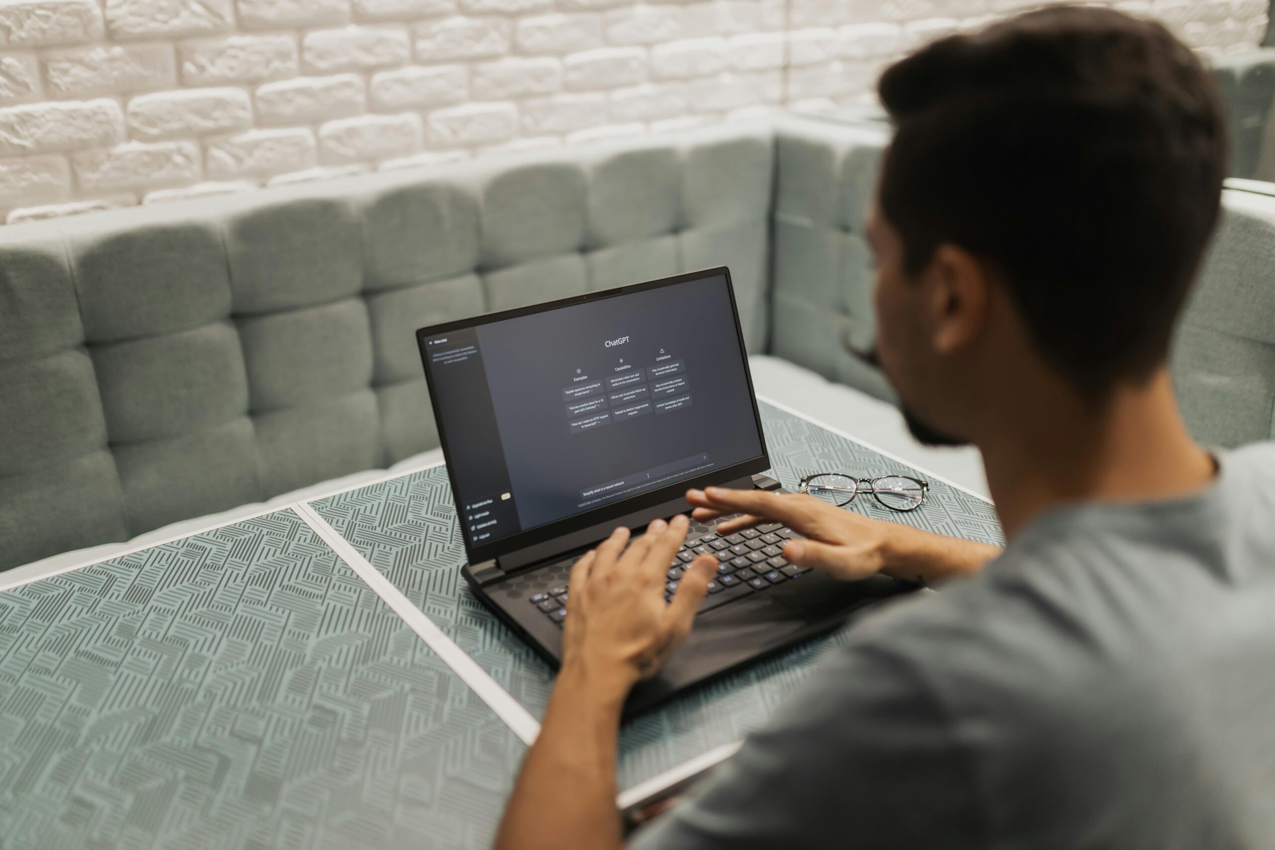 Person working on a laptop on a patterned table.