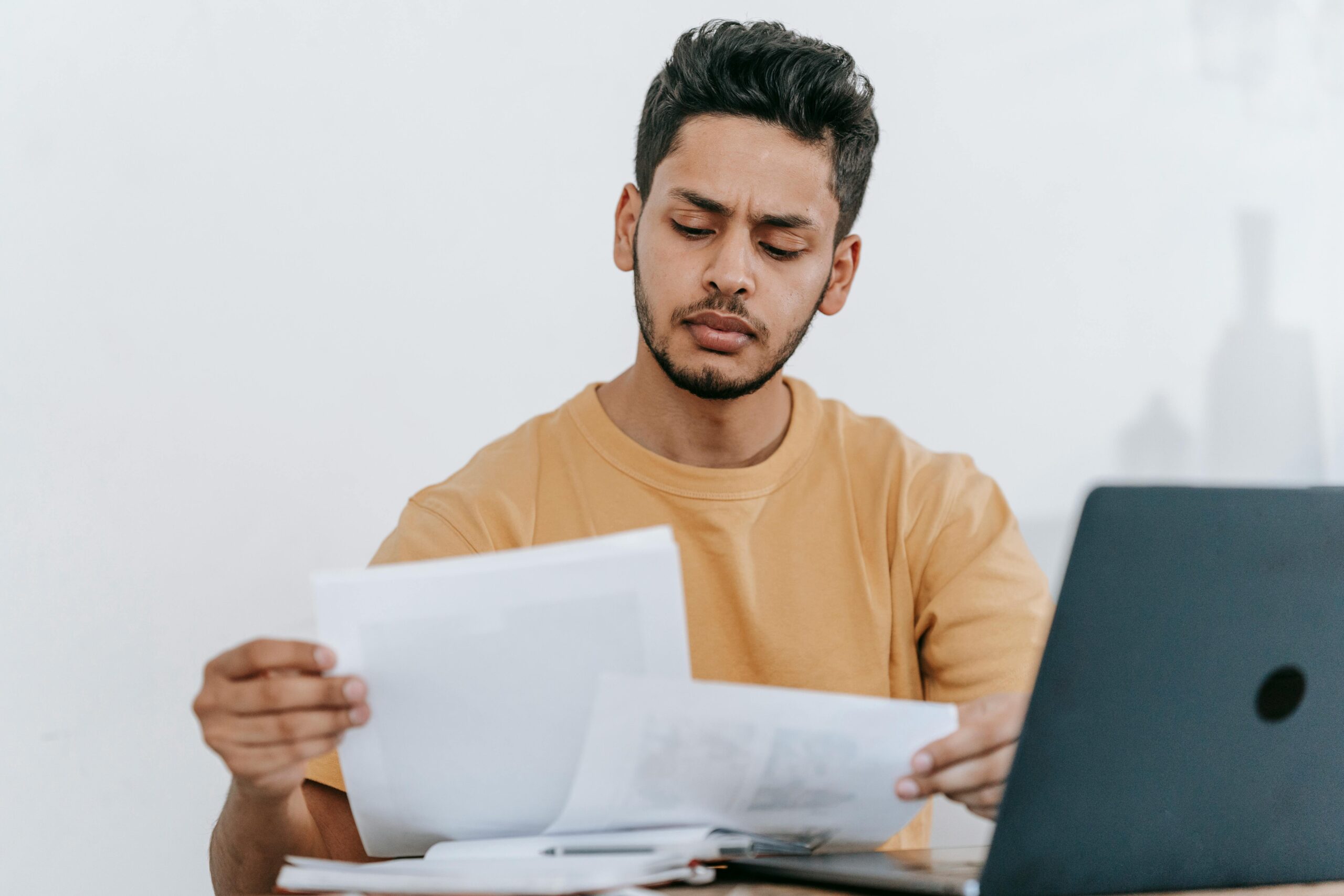A man evaluating documents, signifying the detailed analysis conducted in customer care outsourcing service.