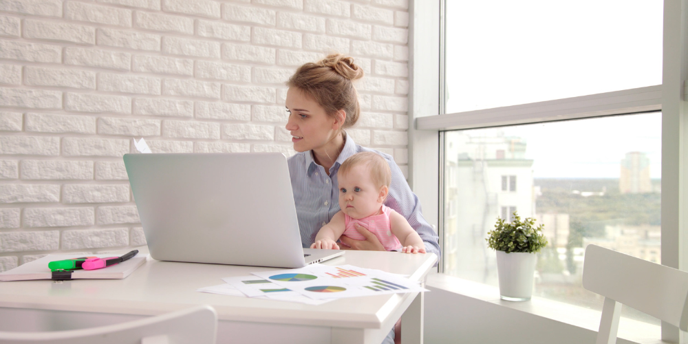 A parent working with a baby on their lap.