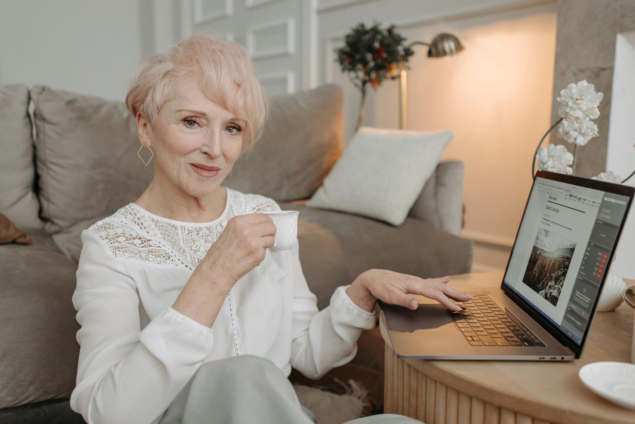 B2B Lead generation: Person on couch with laptop and cup, strategizing lead generation in a comfortable setting.