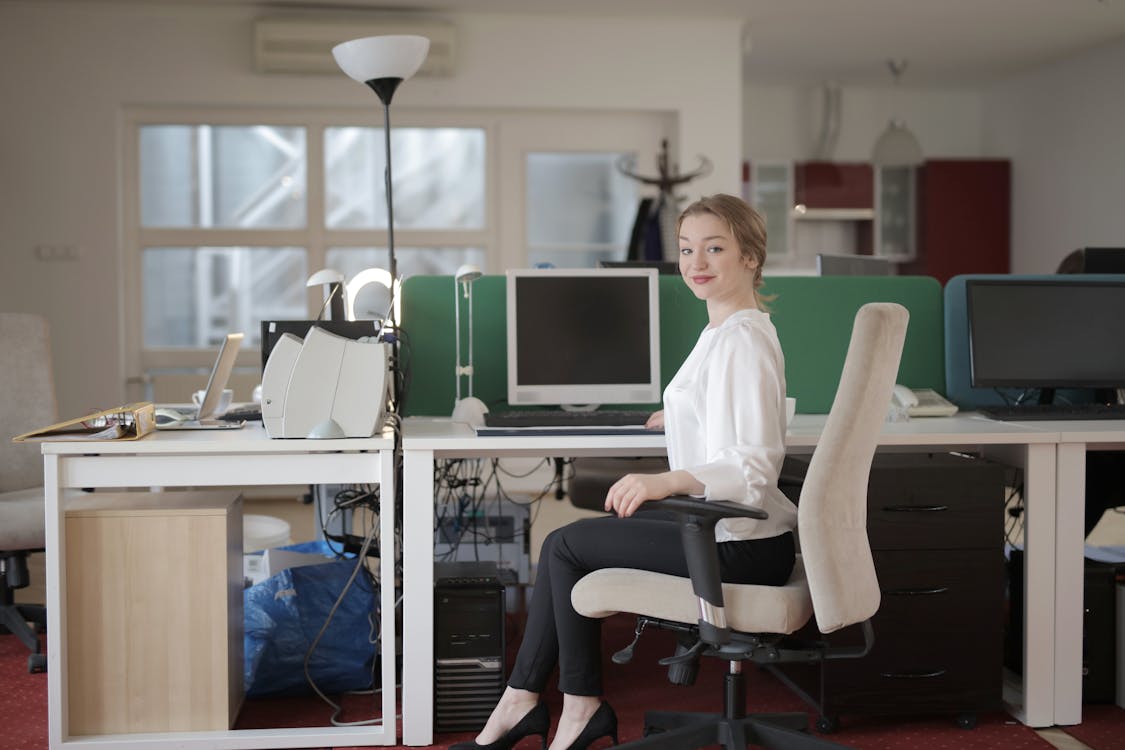Gratis Empleada Elegante Sentado En Una Silla En El Lugar De Trabajo Moderno Foto de stock