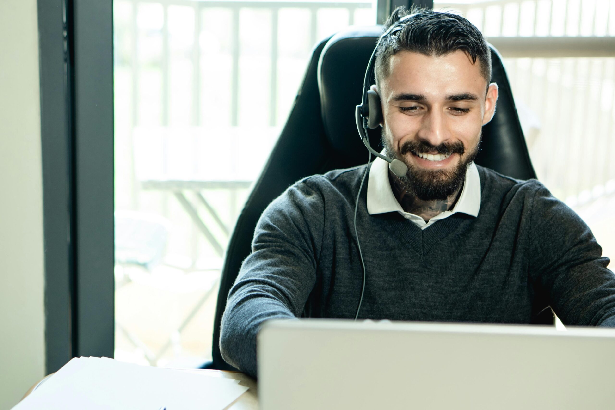 A happy male customer service representative outsourcing support calls, showcasing professionalism and engagement.