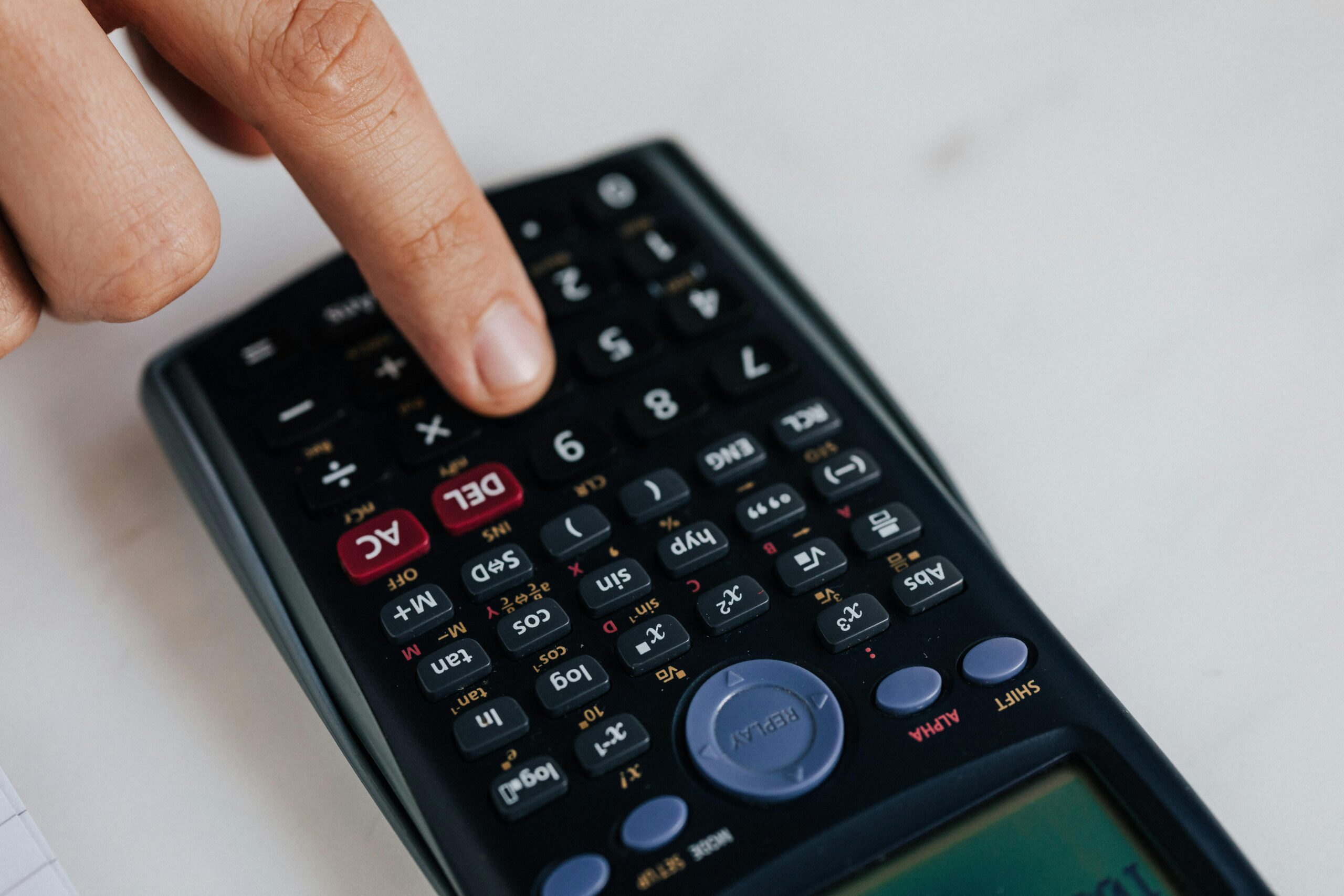 Close-up of a hand using a calculator for financial analysis.