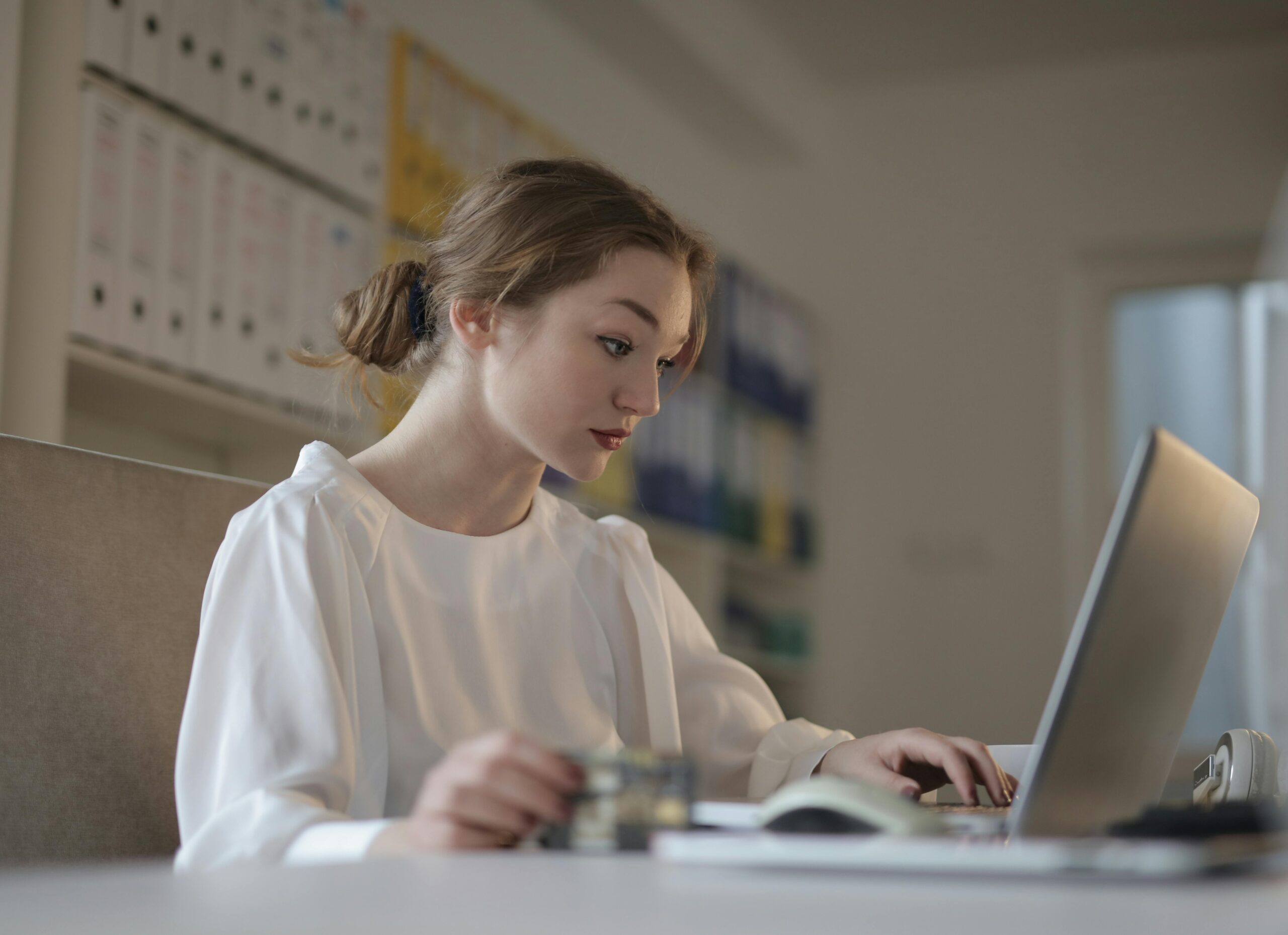 A businesswoman working on a laptop in an office to hire accountants.