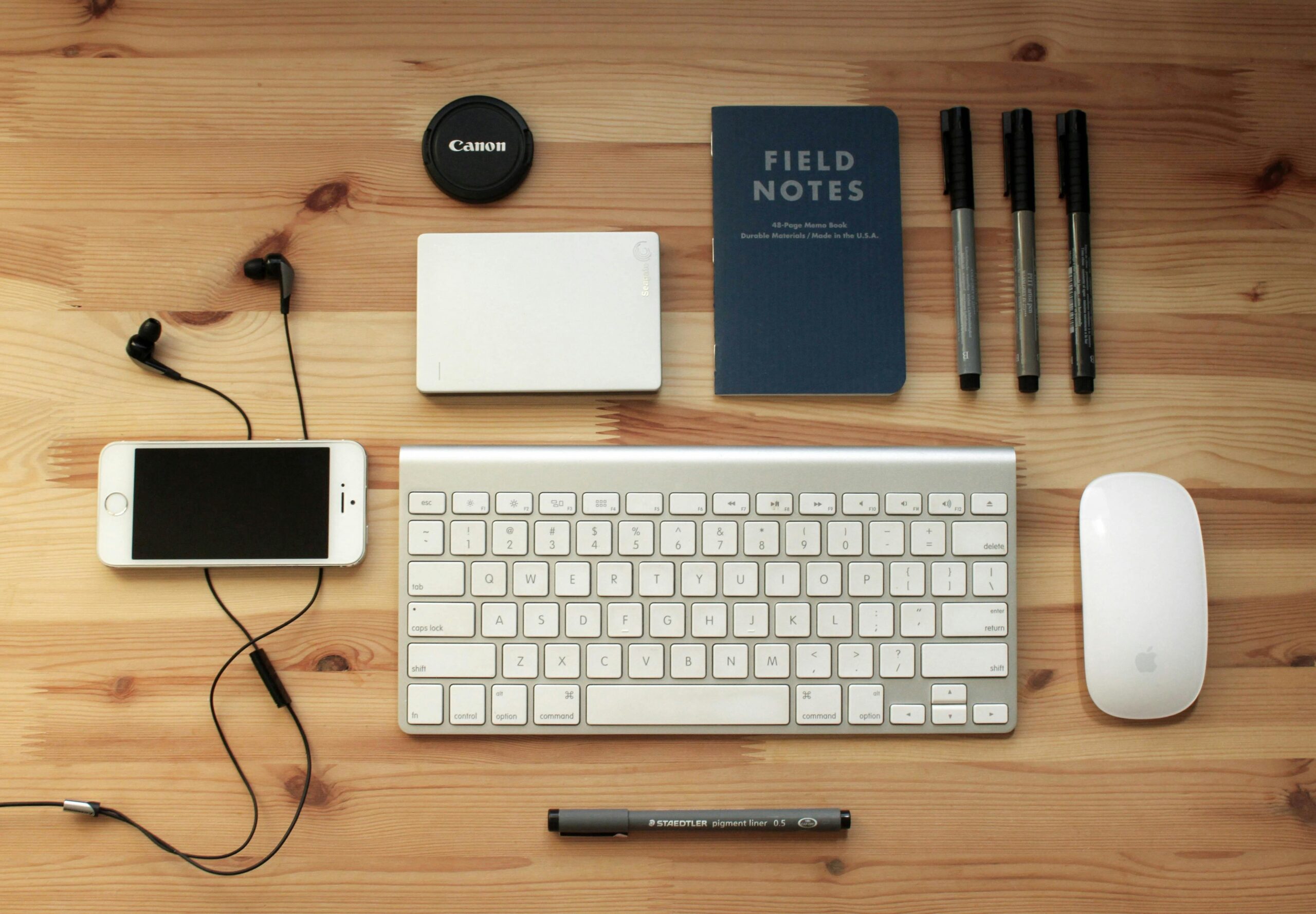 Organized desk with gadgets and notebook.