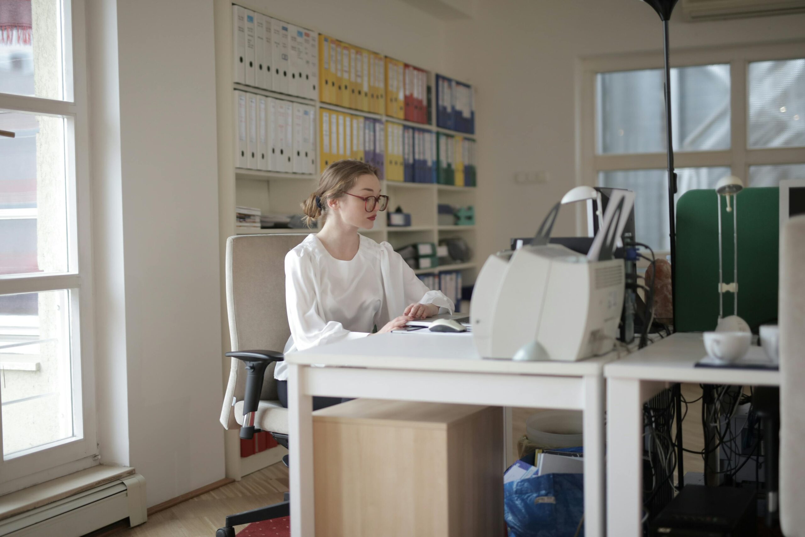 Professional bookkeeper for hire working in an organized office space with files and binders.