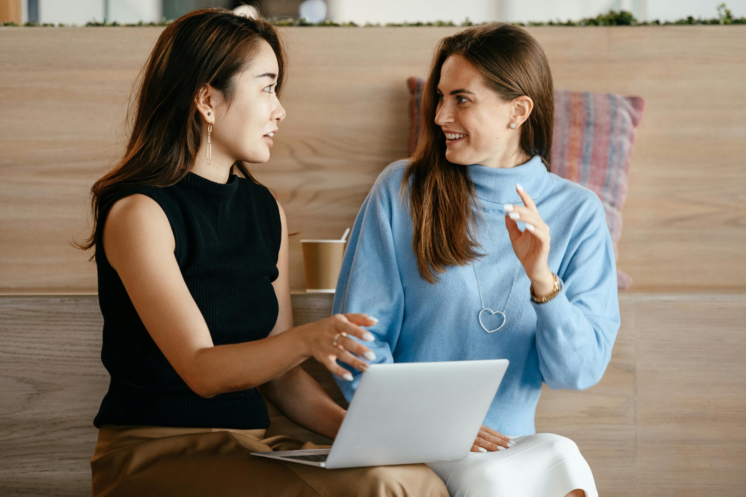 Two women discussing hiring strategies.