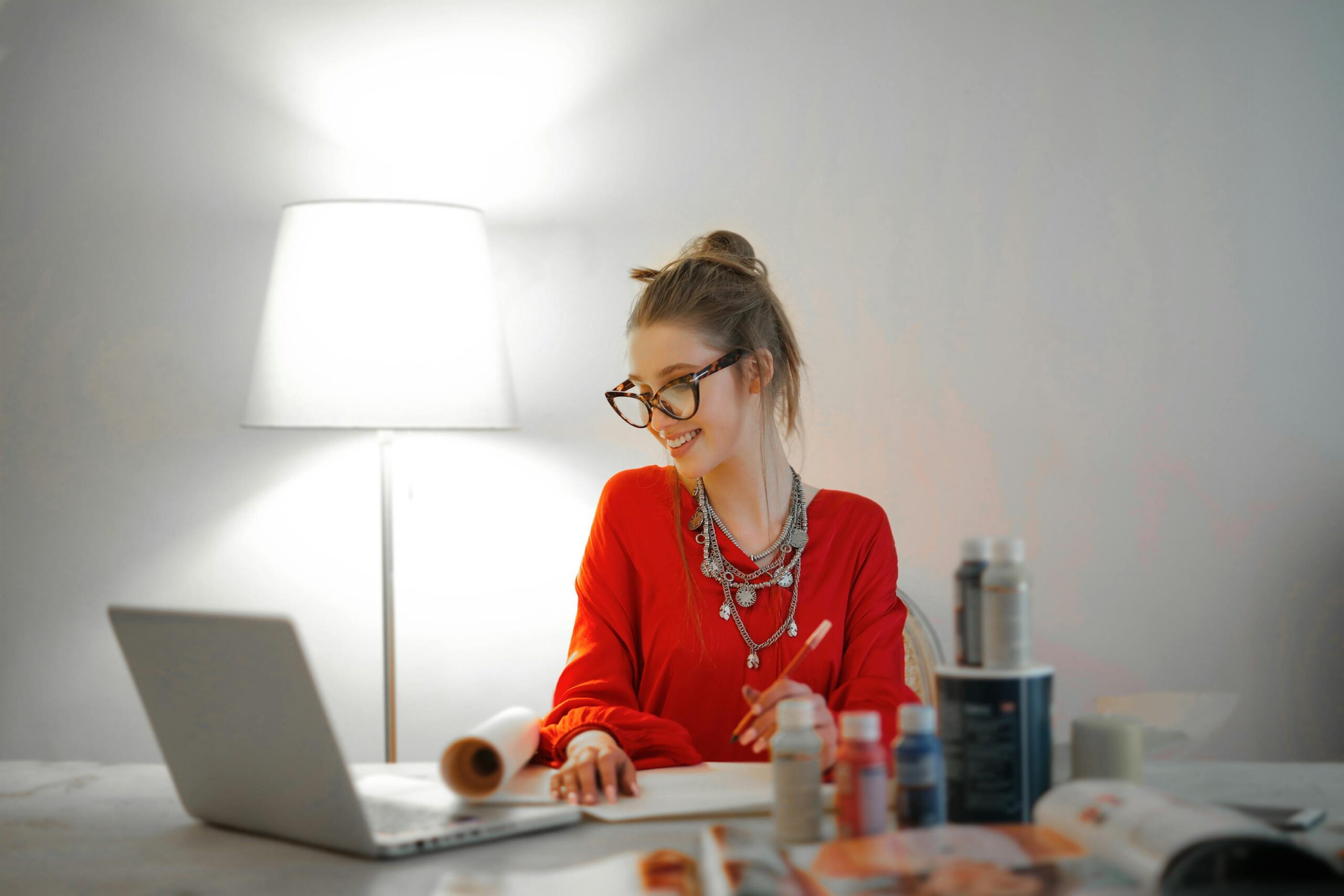 Woman in red working on a laptop, exemplifying efficient outsourcing in marketing.