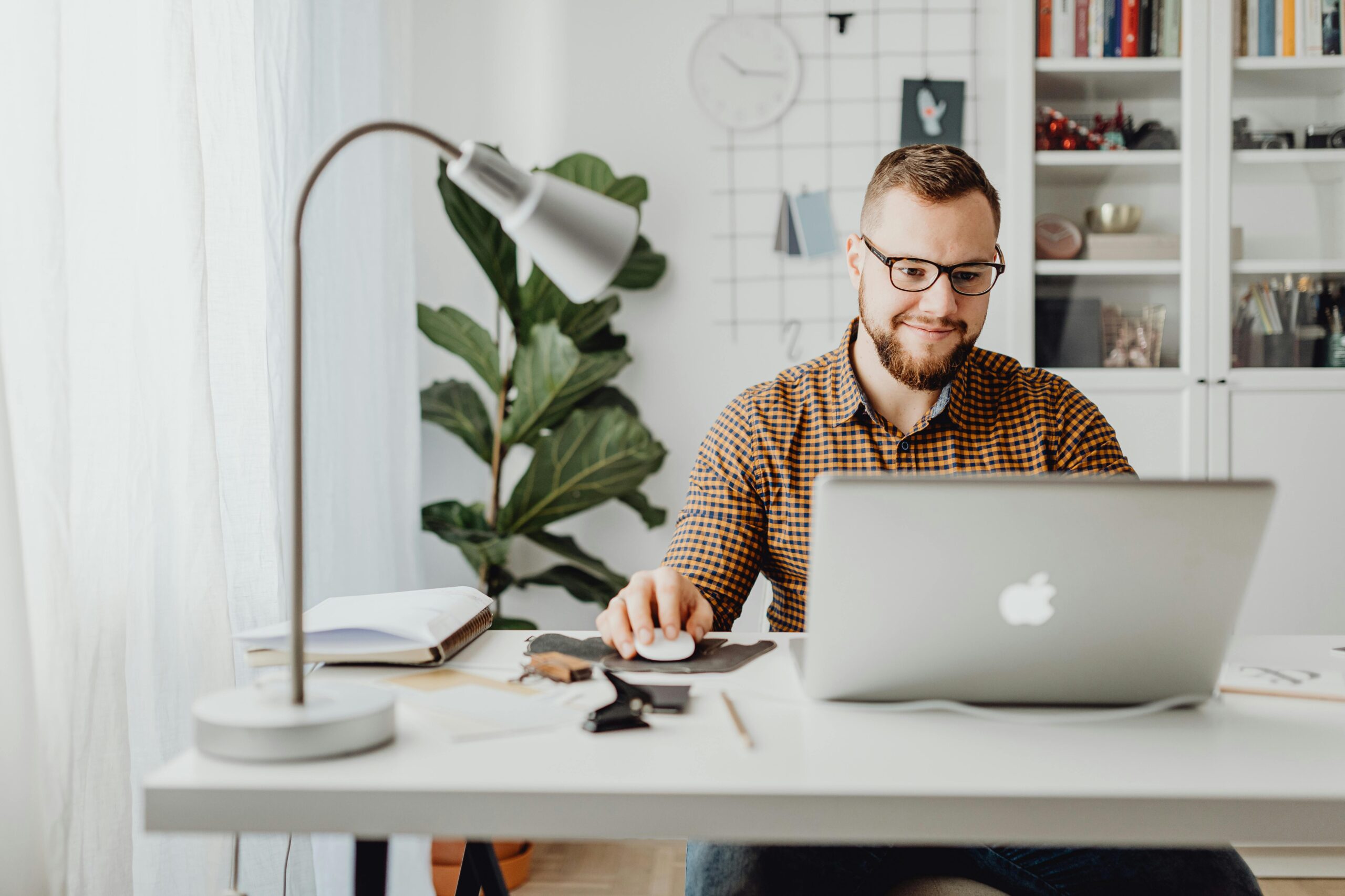 Man working at a home office desk with a laptop, demonstrating remote work experience for the resume of a marketing manager.