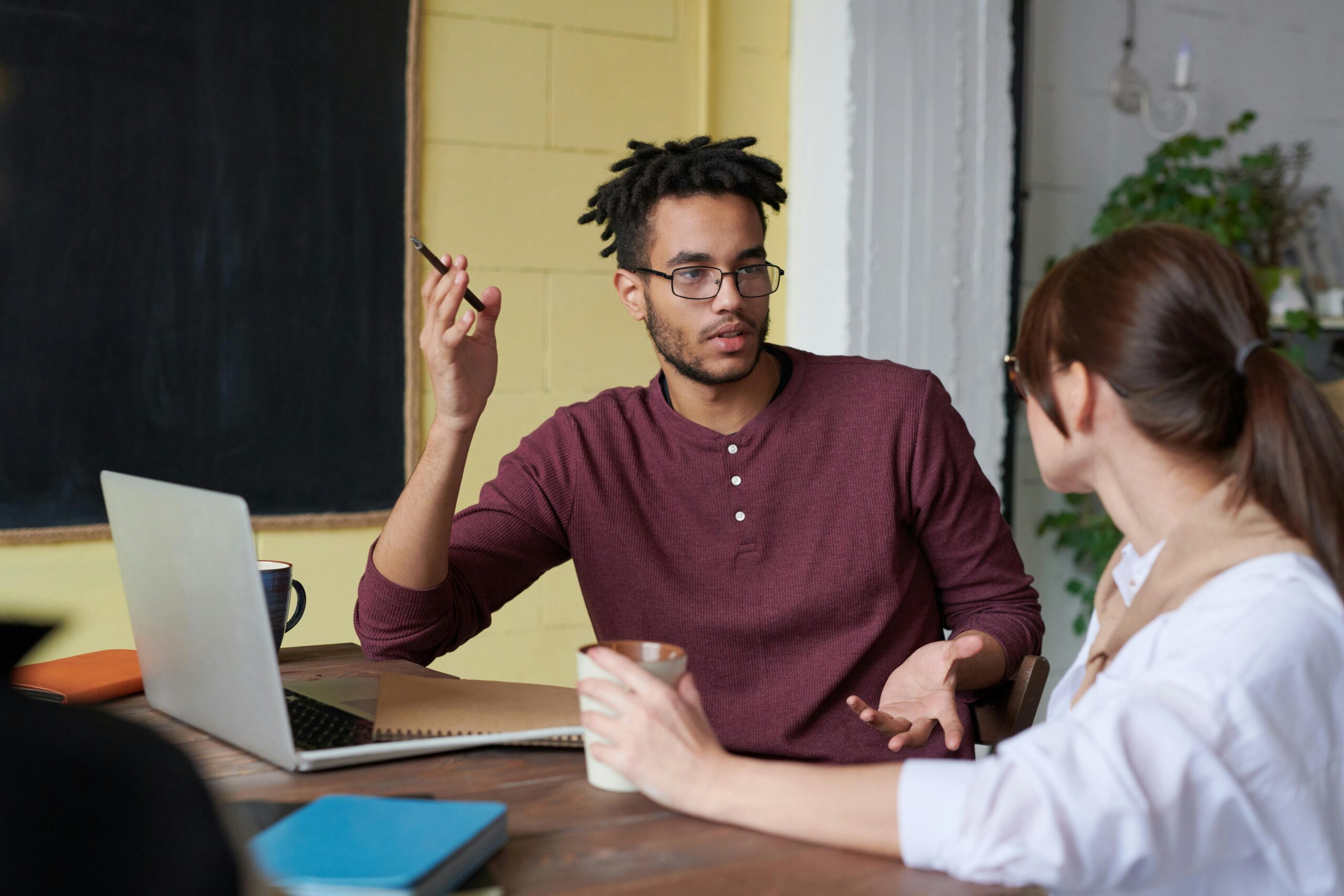 Two people in a discussion, one explaining a point, representing offshore teams.