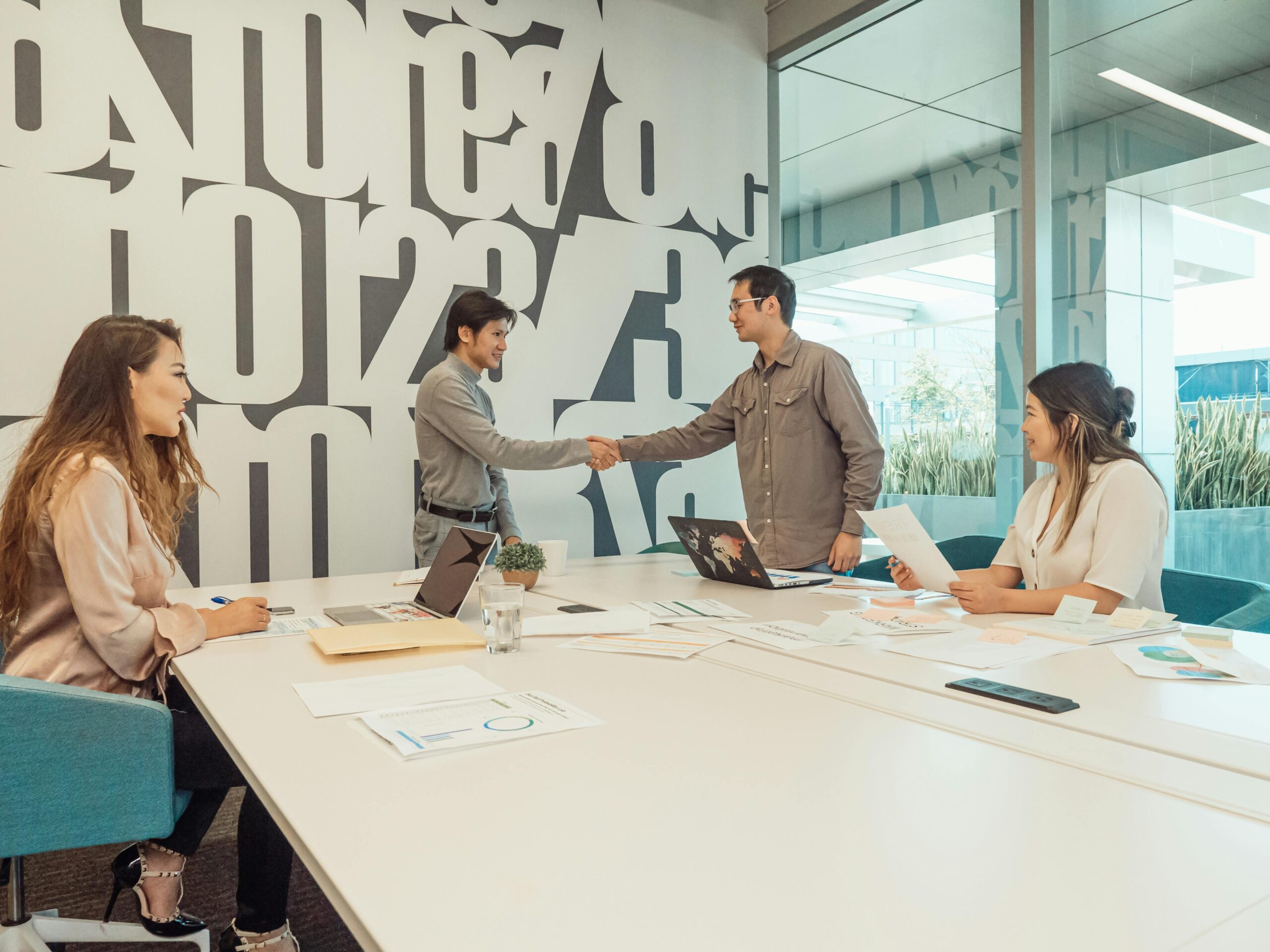 A team session with employees shaking hands in a meeting room.