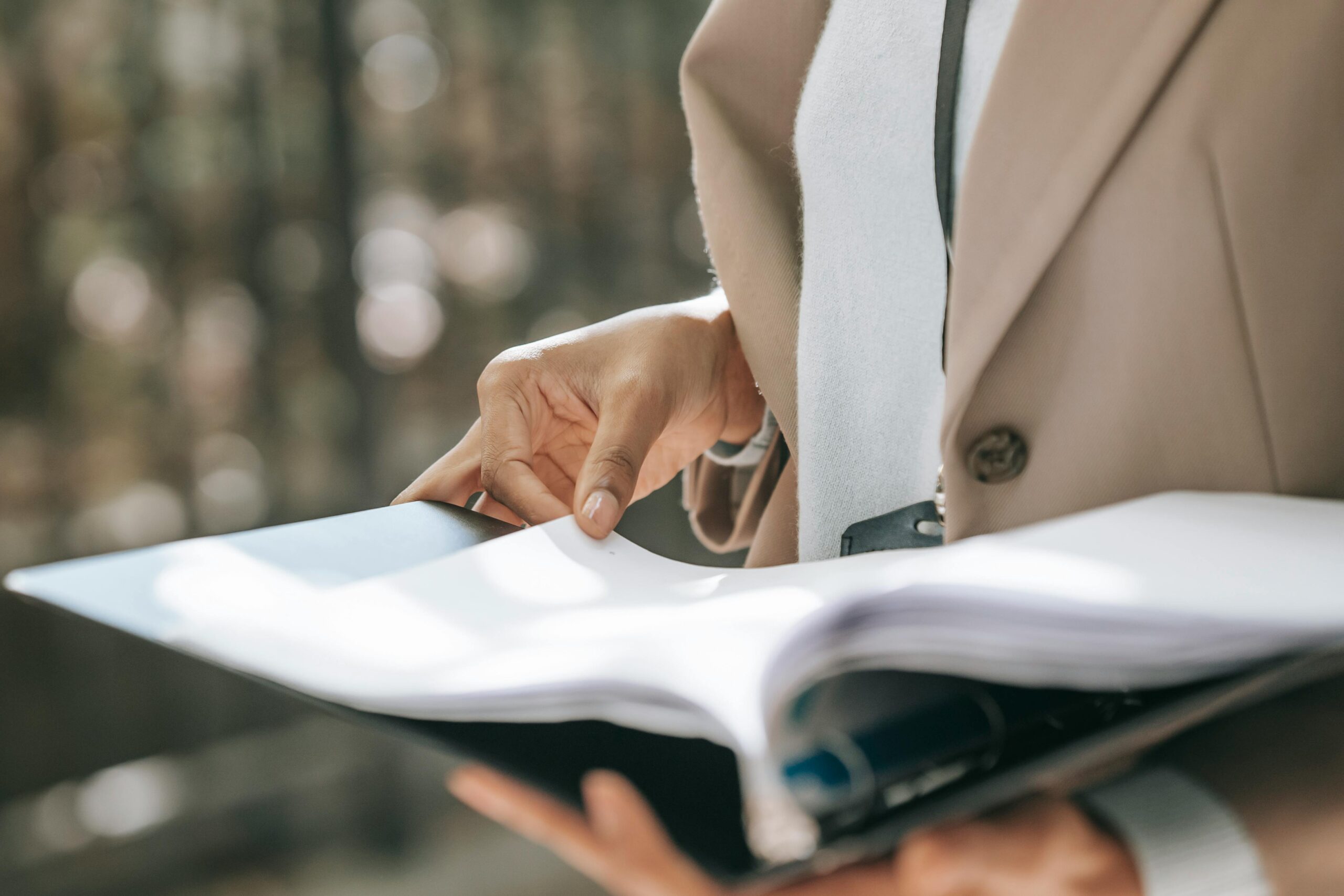 A professional reviewing a contract for recruitment agency services while standing outside.
