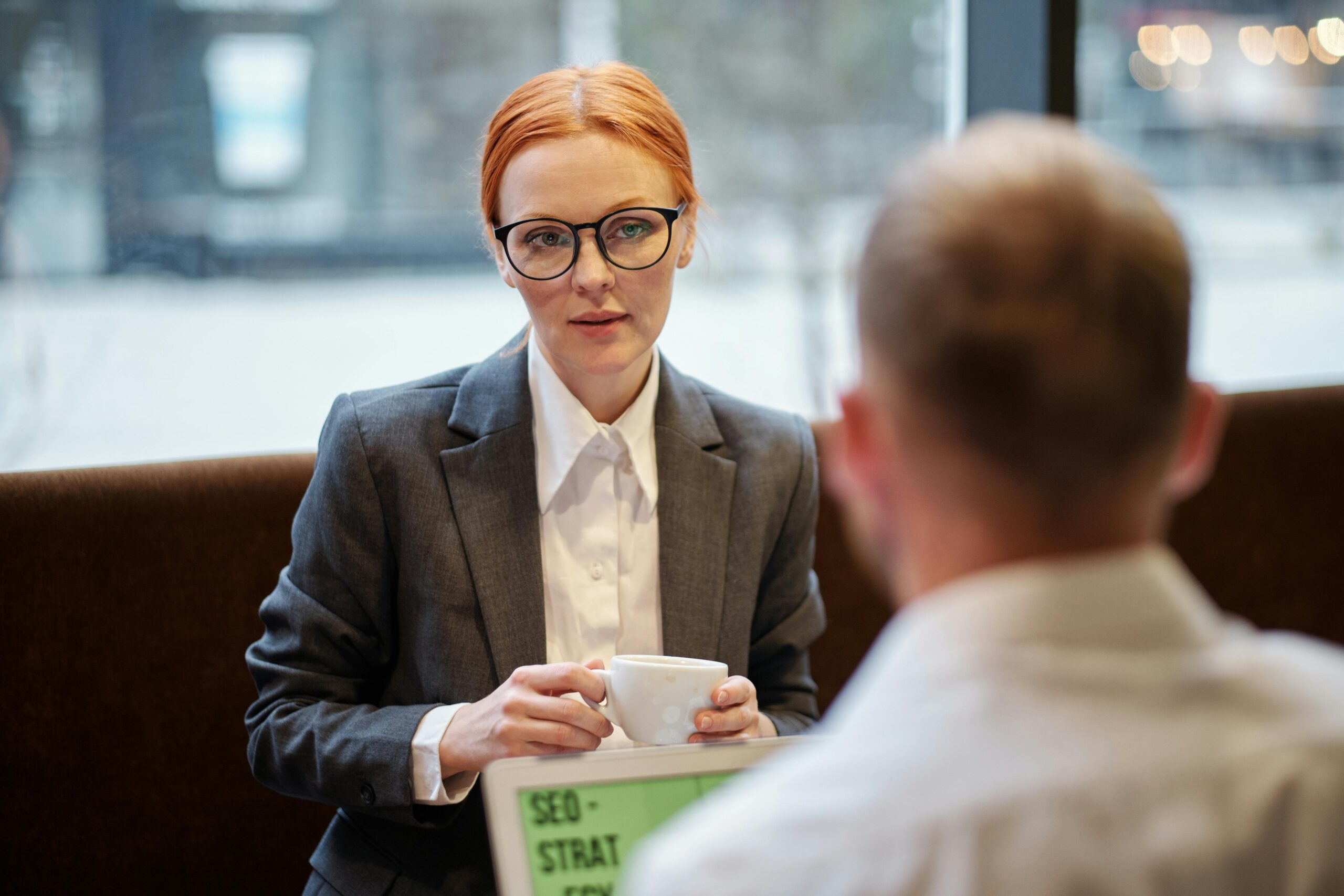 A serious conversation between two professionals, discussing talent retention strategies.