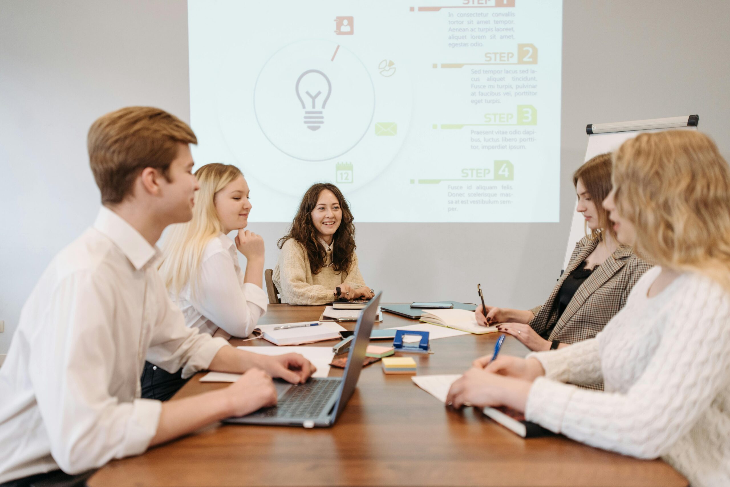Two marketing professionals working on laptops, depicting focused work involved in hiring a marketing manager.