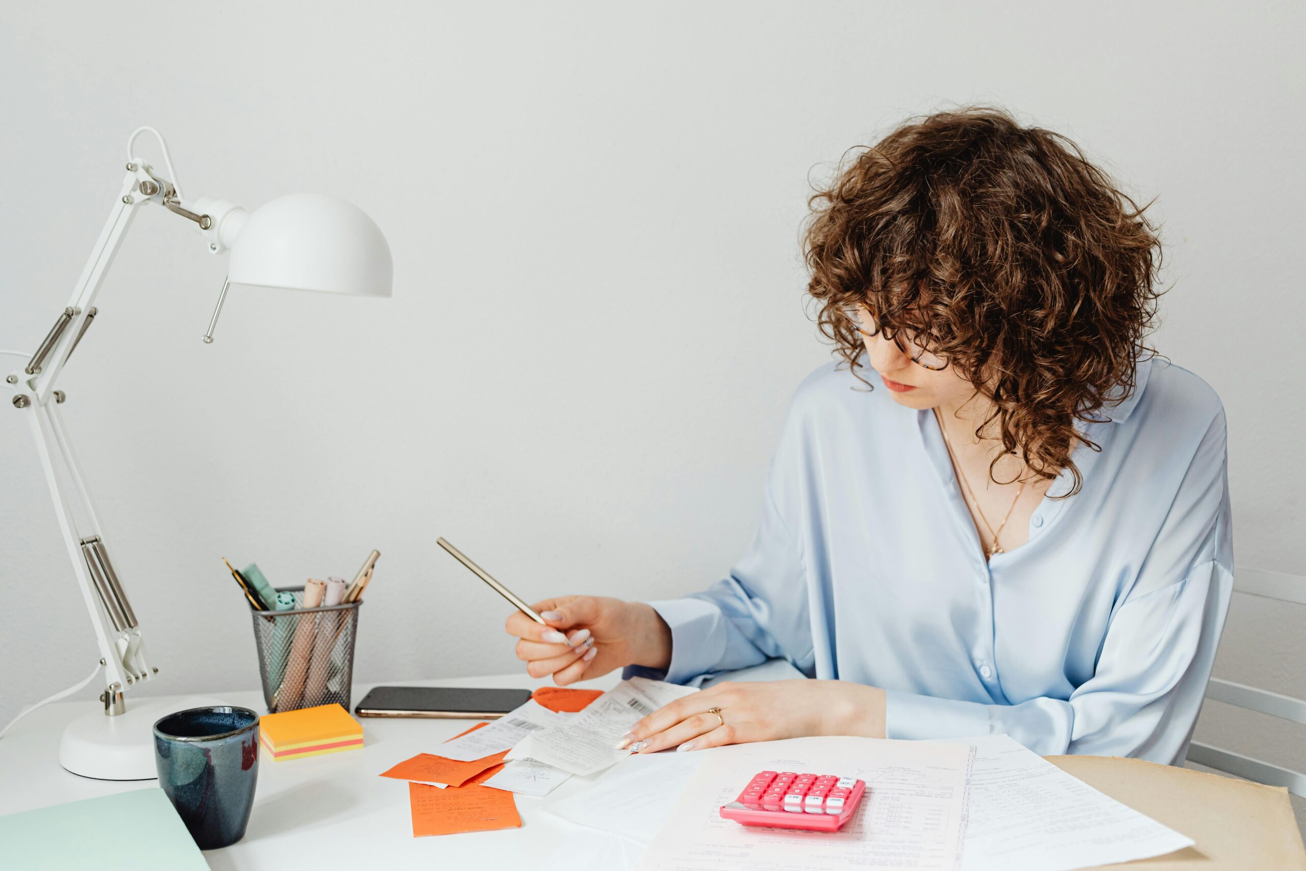 Woman reviewing financial documents at a desk. Evaluating the benefits of outsourcing accounting services.