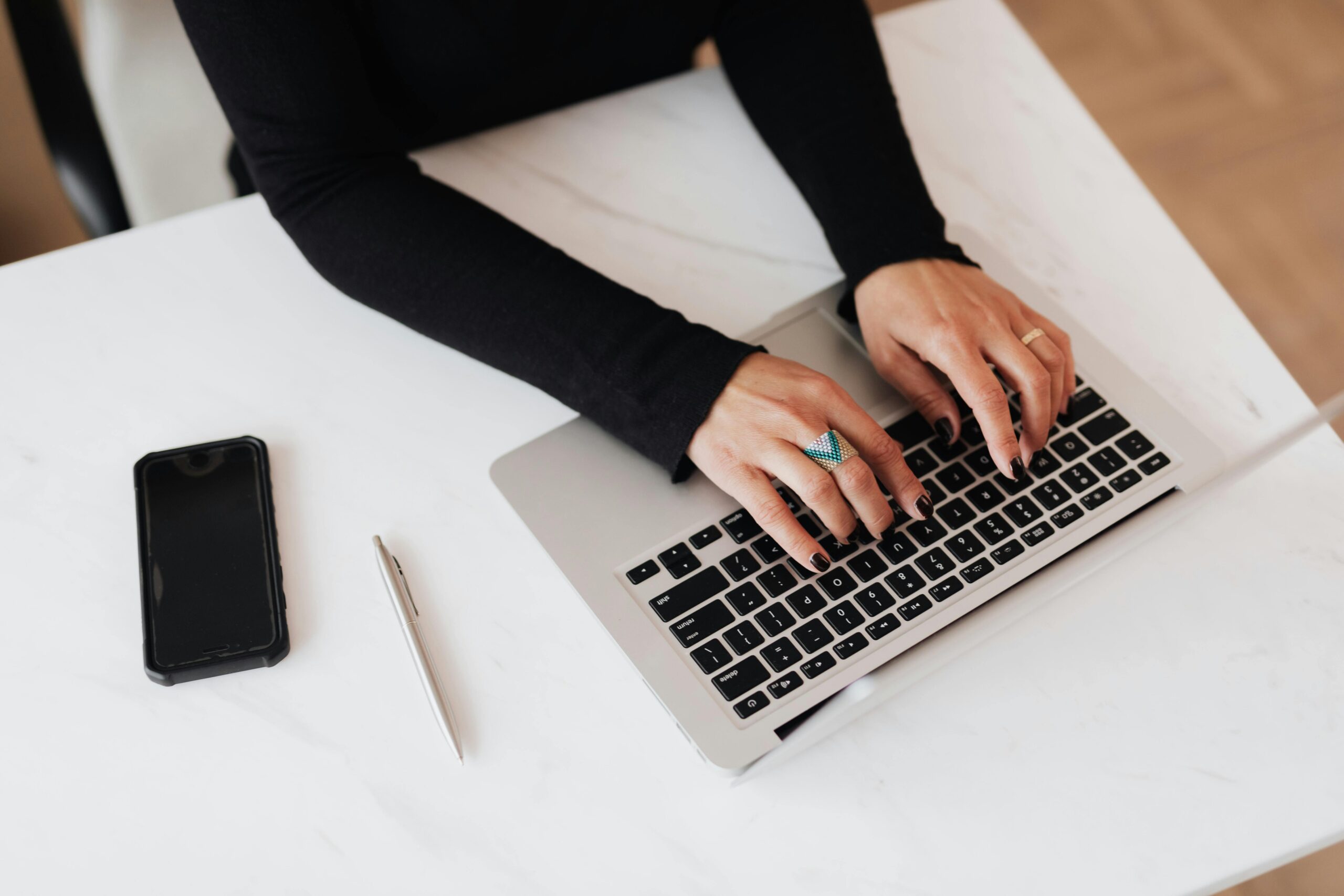Woman typing on a laptop.