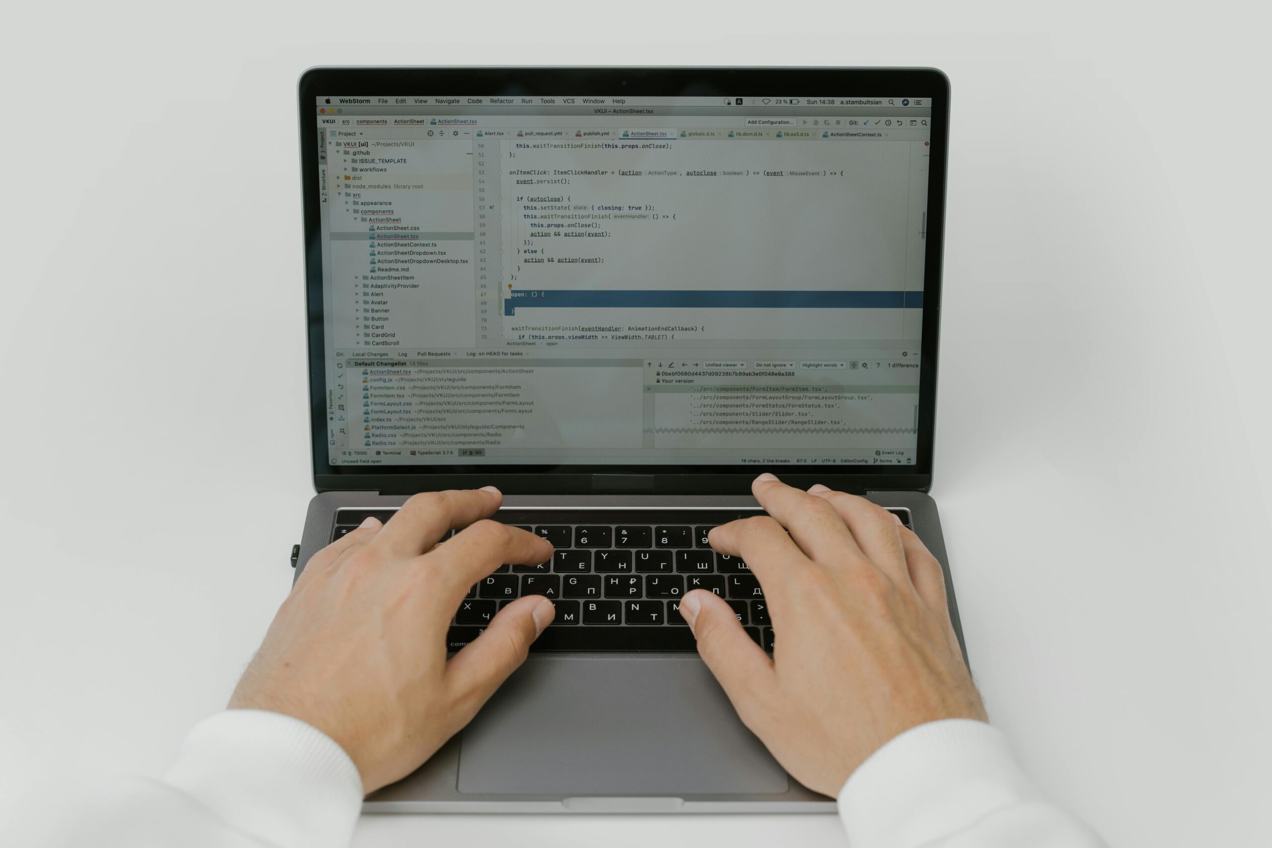 Hands typing code on a laptop.