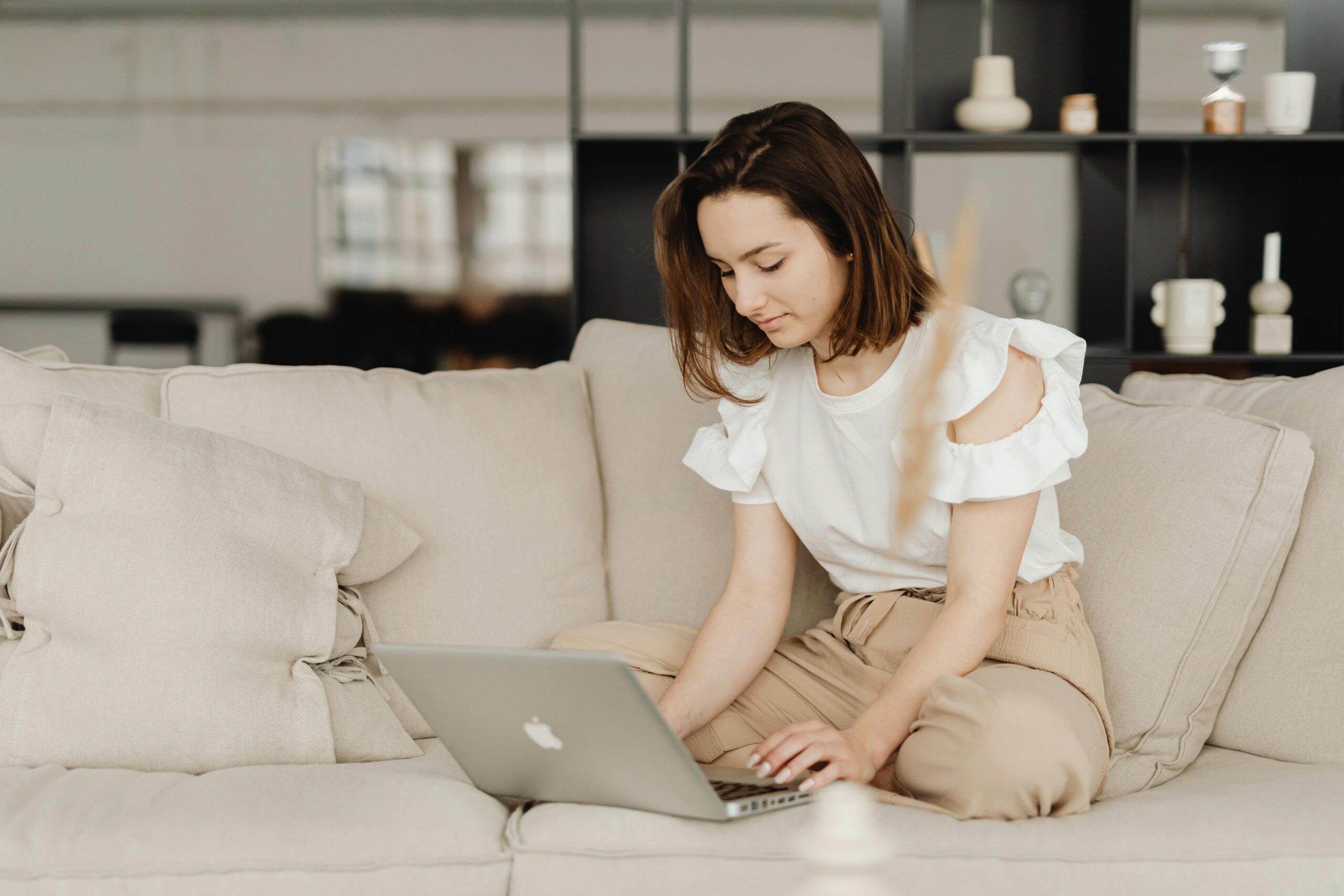 Woman working on remote sales from a comfortable home setting.