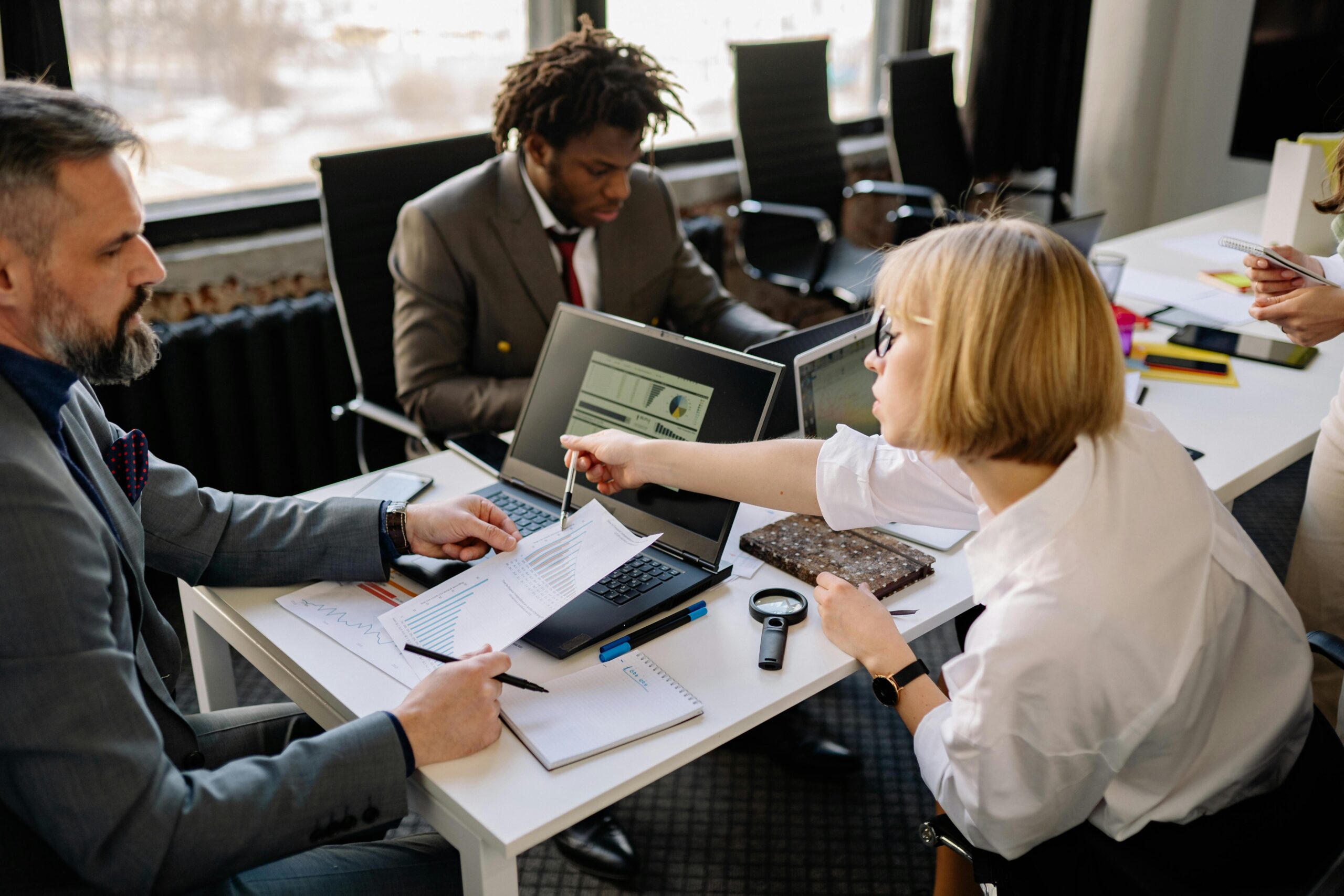 A business meeting with professionals discussing documents and data, showcasing the strategic approach of staffing firms.
