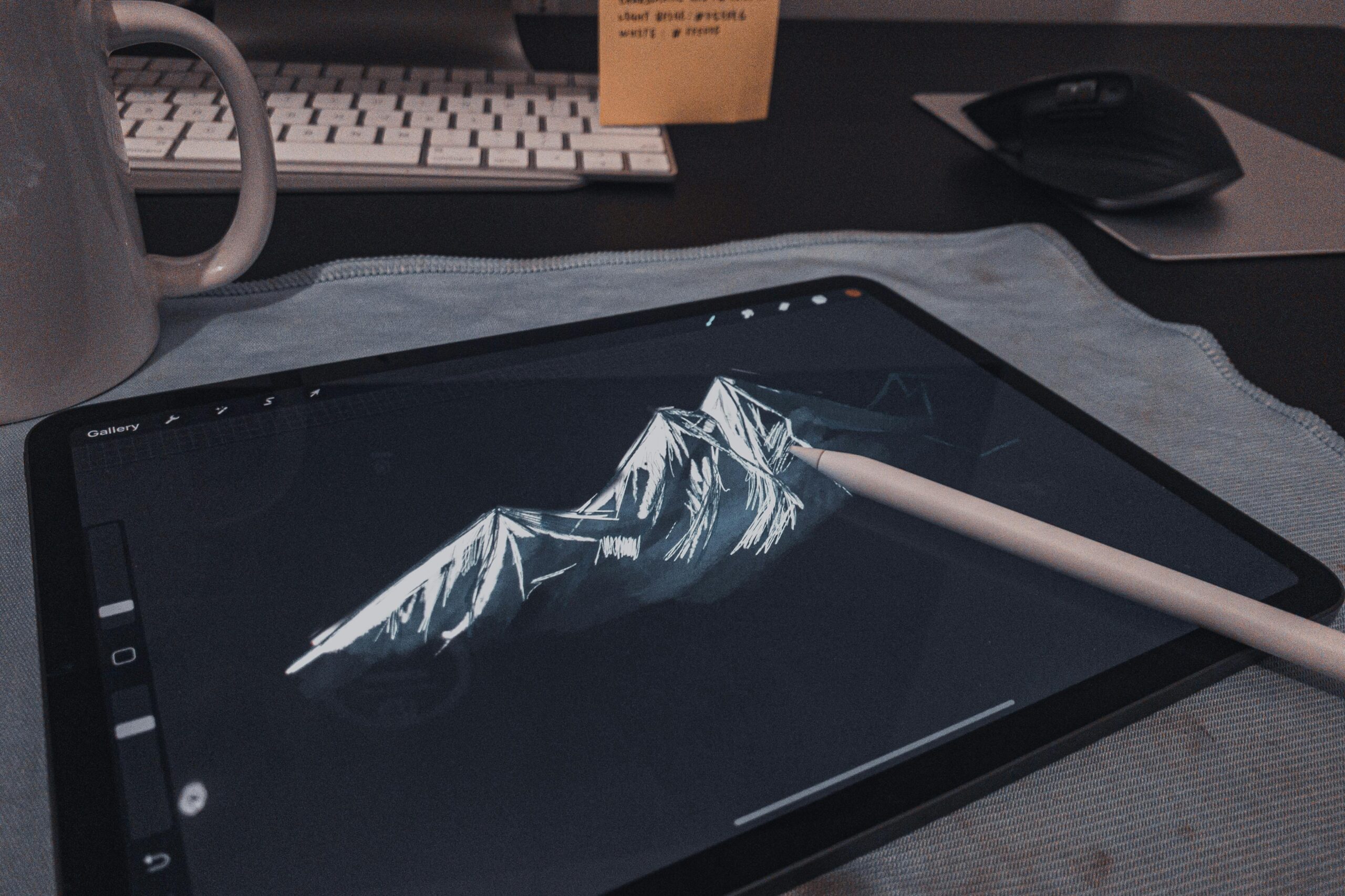 Digital sketch of a mountain logo on a tablet.
