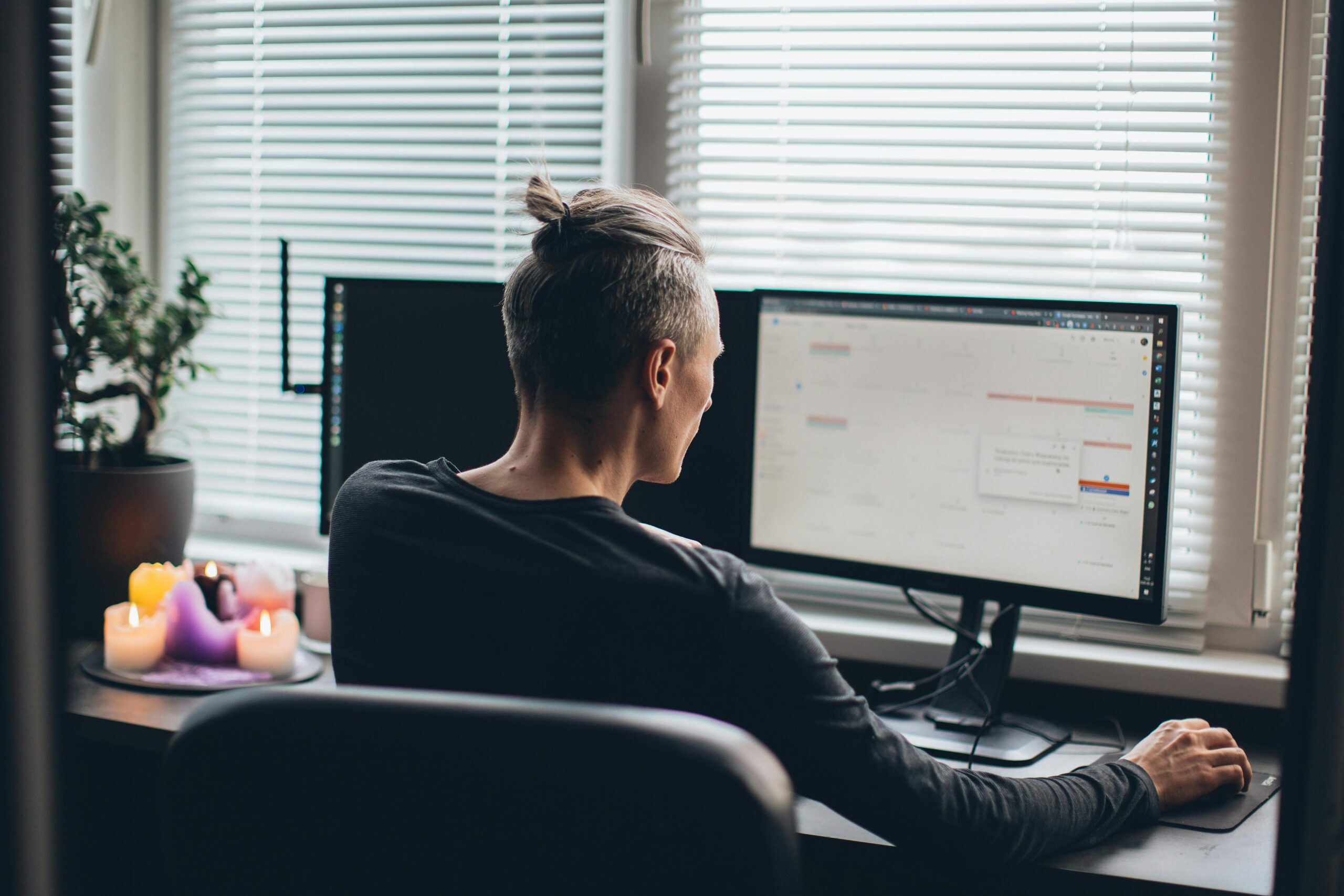 Man working on dual monitors for companies hiring remote workers.