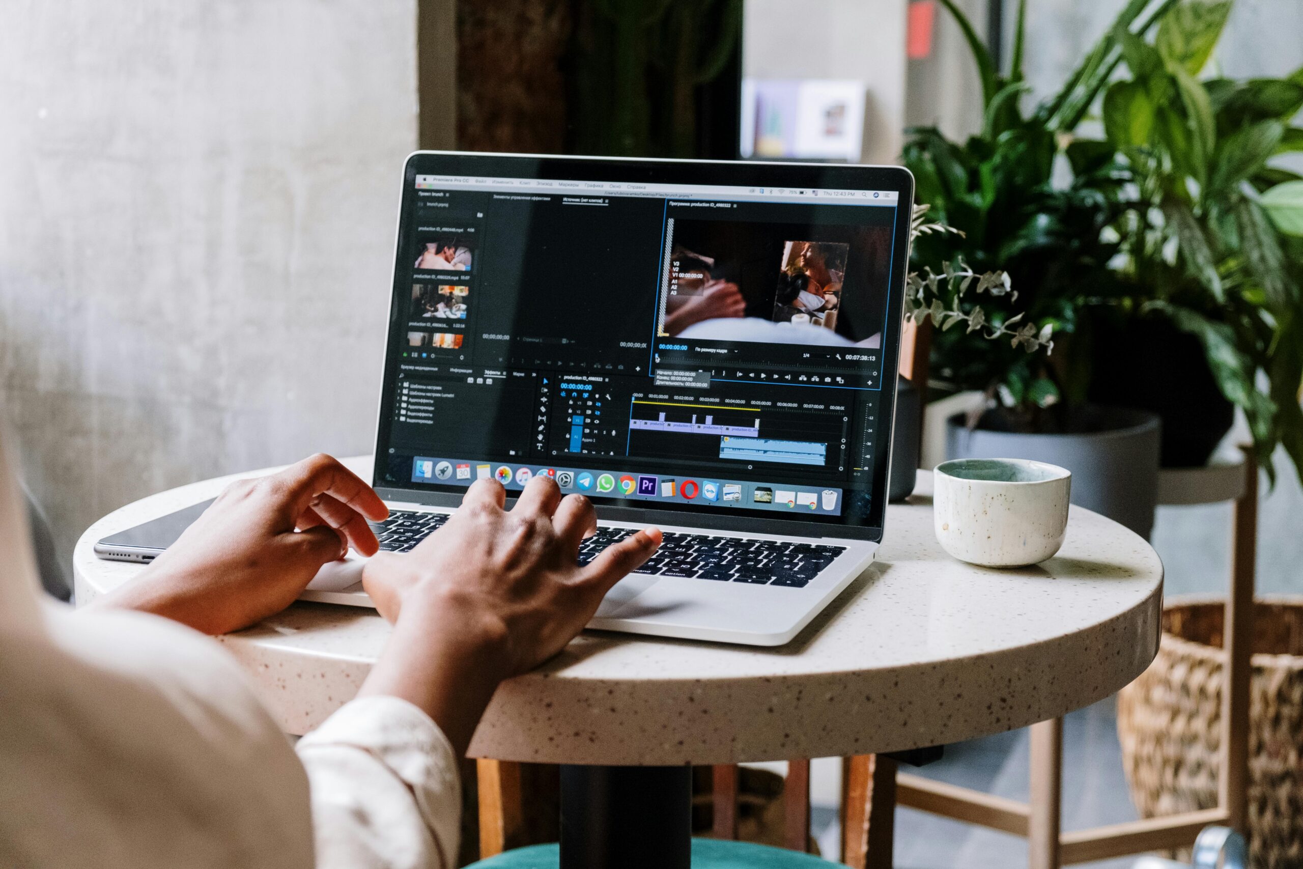 Remote designer editing video content on a laptop.