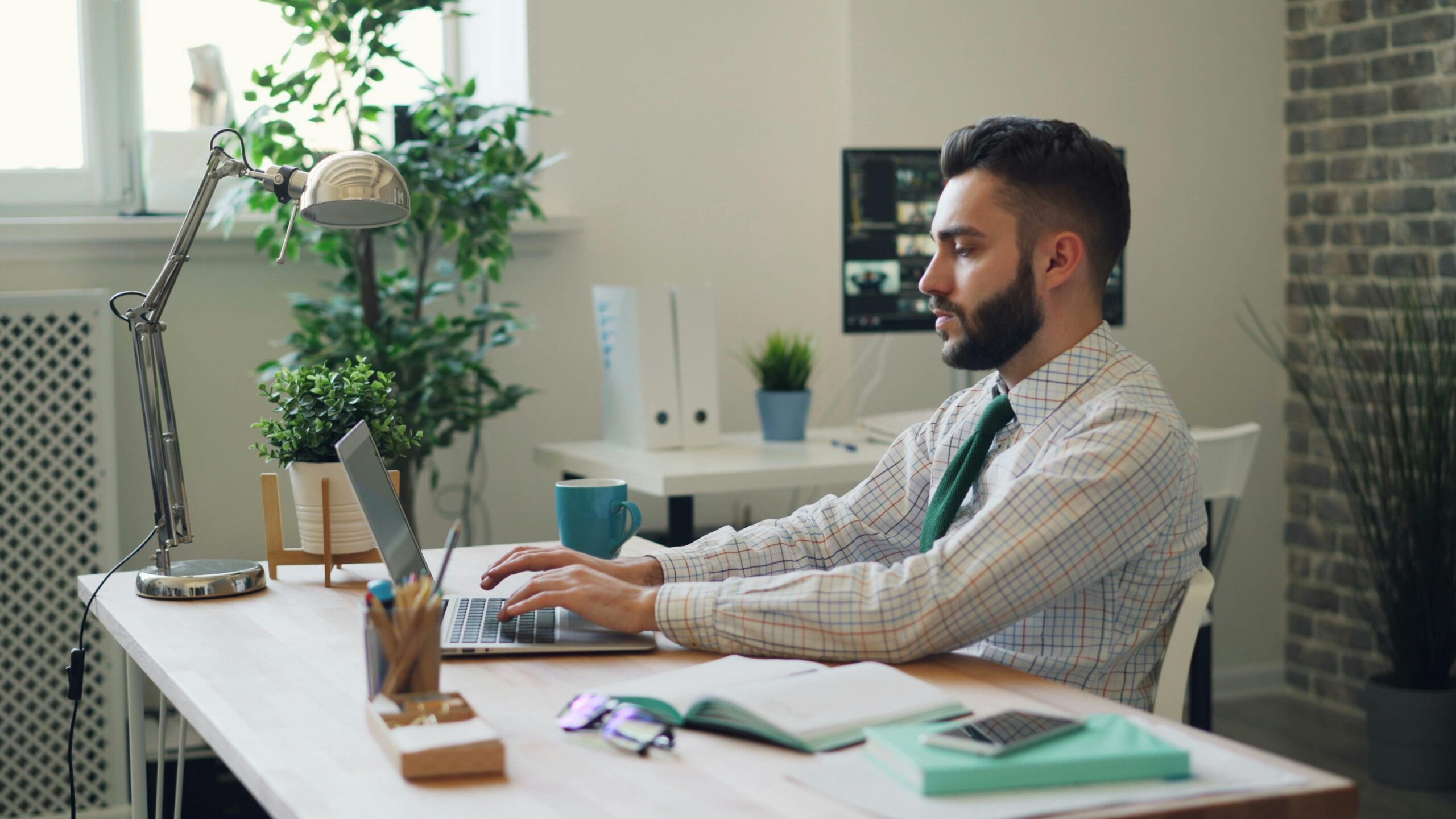 Man working on a laptop in a modern office.