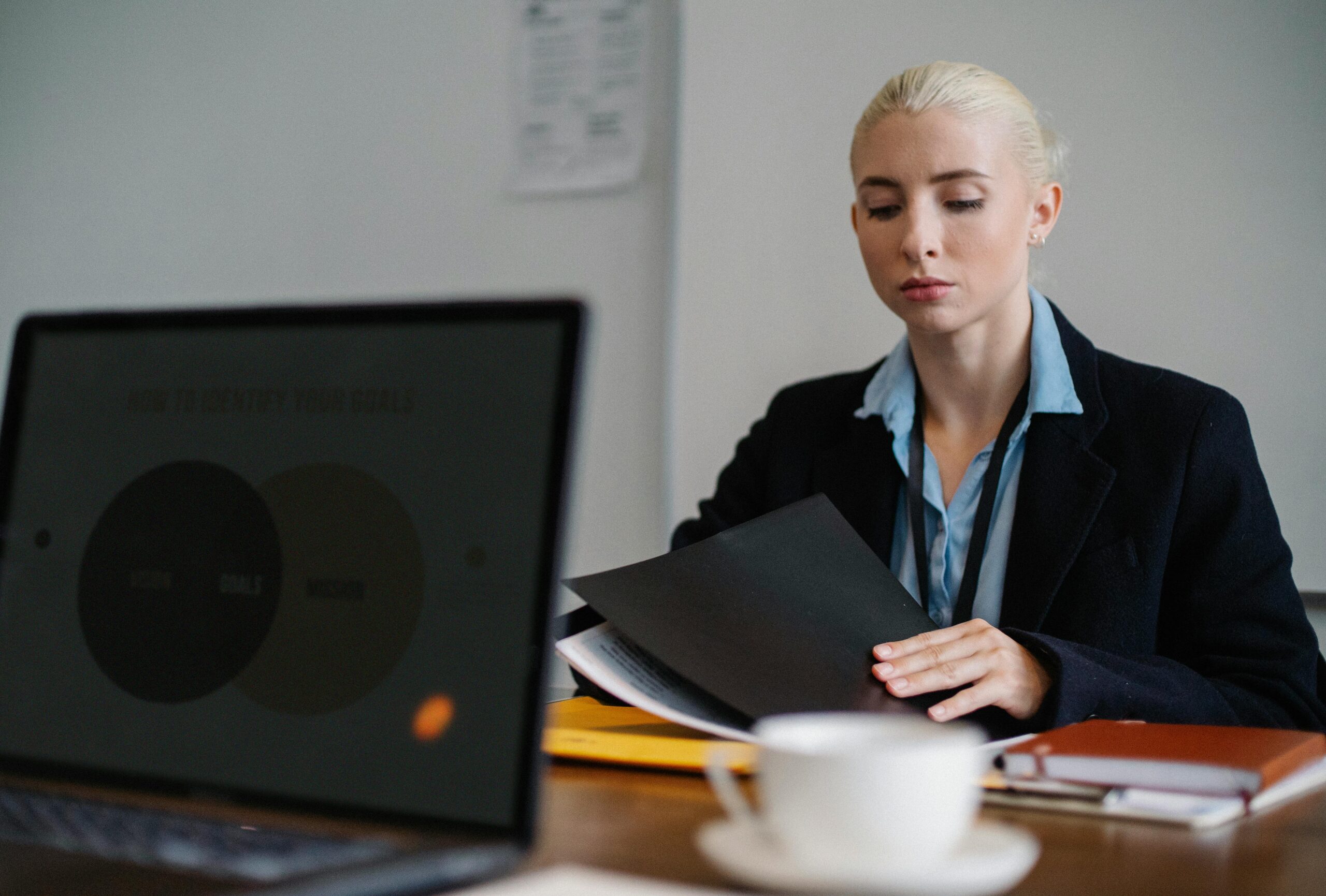 A professional woman reviewing documents and preparing interview questions.